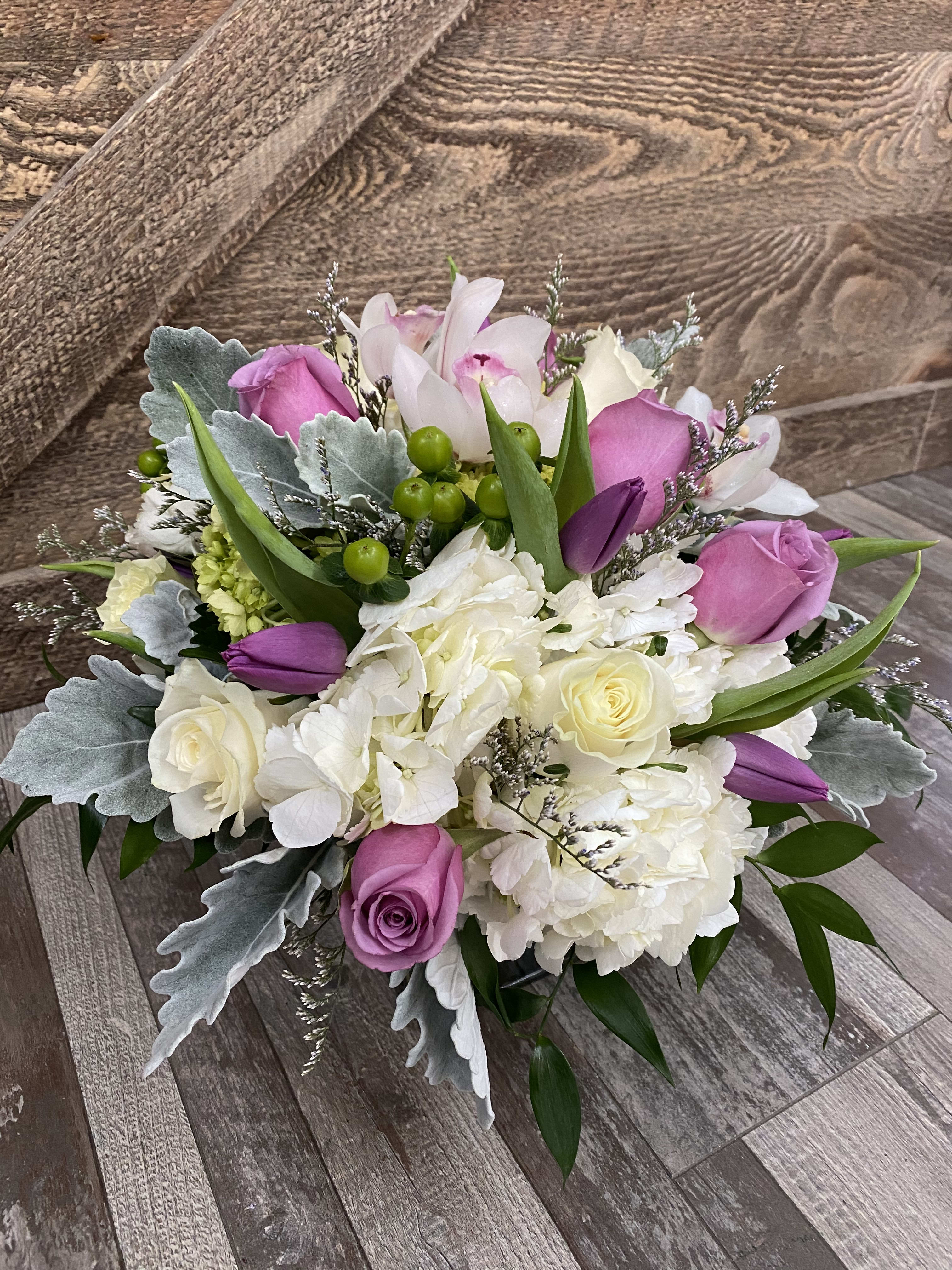 Lavender Dreaming - One of my favorite arrangements. Includes lavender roses, hydrangeas, dusty miller, hypericum berries, cymbidium orchid blooms, tulips and caspia. Version shown is the deluxe.