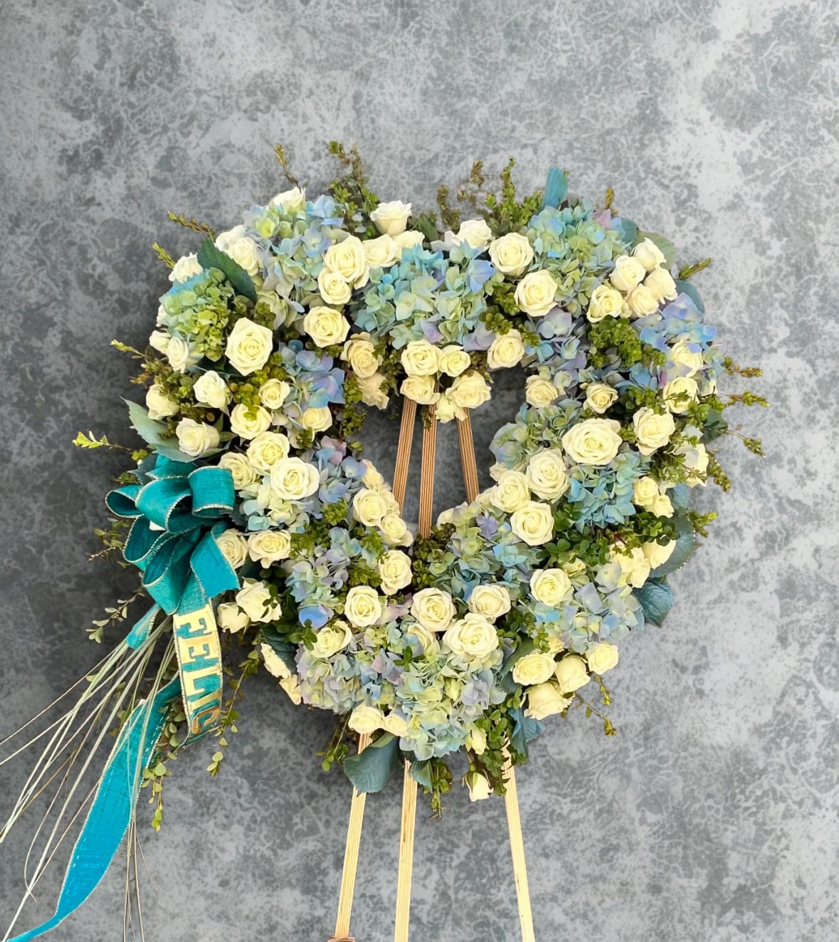 Sky Blue  - This beautiful arrangement comes in a stunning mix of blue hydraenids, white spray roses and its greenery a wonderful way to share peace, love and respect.    