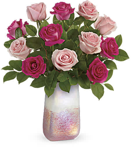 Teleflora's Rose Quartz Kisses Bouquet - Make Valentine's Day sparkle with this stunning bouquet of one dozen pink roses, artfully presented in a rose quartz inspired, hand-blown art glass vase with a gorgeous iridescent finish. 6 hot pink roses and 6 light pink roses are arranged with lemon leaf. Delivered in a Pretty in Quartz vase. Approximately 19 1/2" W x 21 1/2" H 