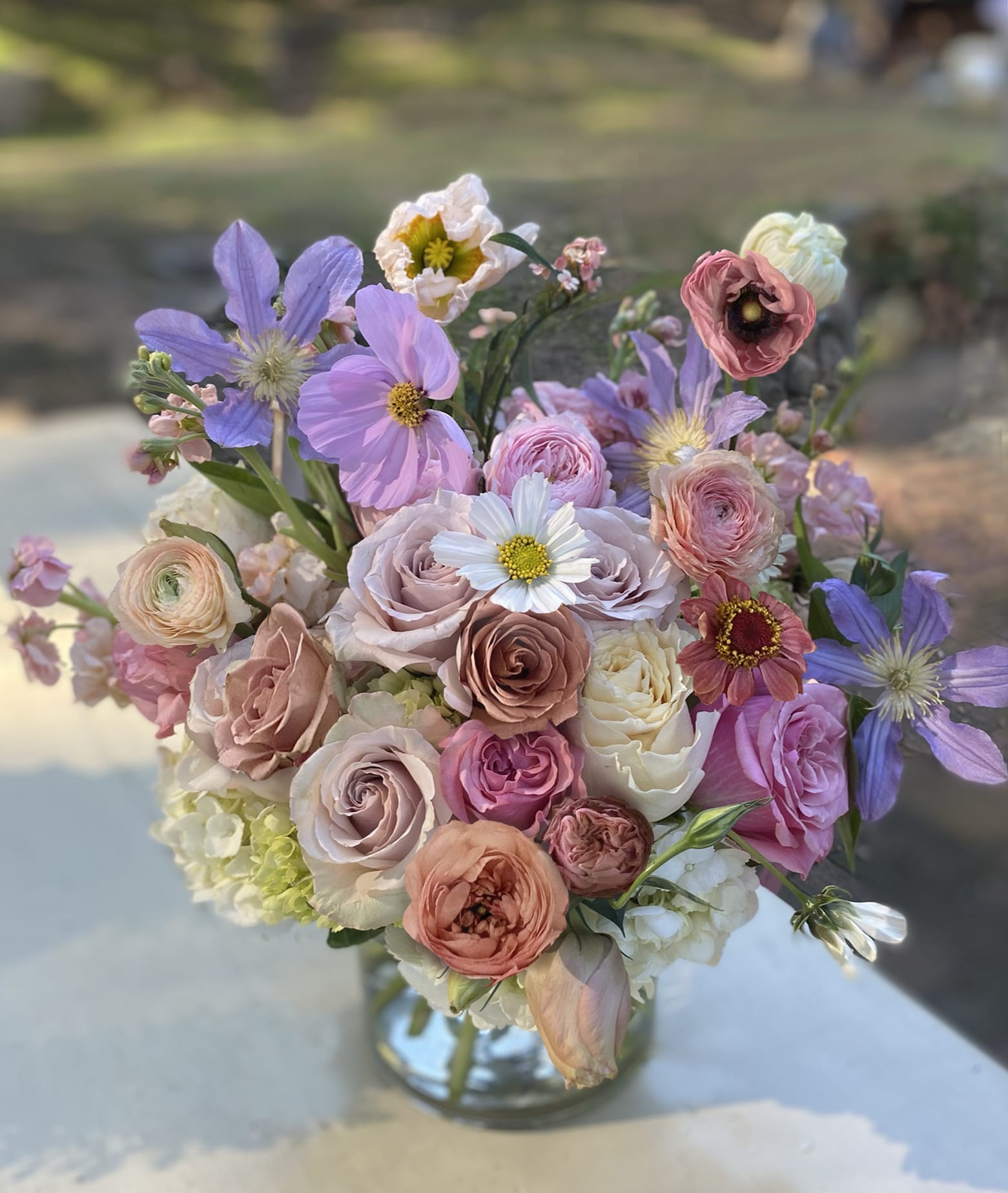 Hayley arrangement - Gorgeous fall colors in a large arrangement of the prettiest most garden-like stems to make it look so natural and free and super elegant. Stems of brown, golden, lavender and purple placed in a 6" by 6" vase. Blomst LA only uses fresh, high quality flowers, all carefully selected every day to fit your flower order. Choose Deluxe for a fuller and larger arrangement with more flowers. Choose premium for the even larger version of the arrangement with even more flowers. We offer a personal hand delivery by our own delivery staff and guarantee the flowers will look perfect, when they arrive. We deliver in Glendale, Pasadena, Eagle Rock, Hollywood, Burbank, Beverly Hills - and everywhere else in Greater Los Angeles.