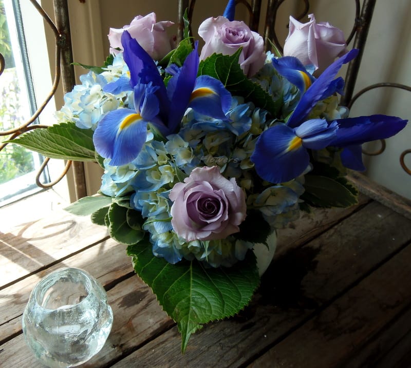 Ocean Wave #s441 - Ocean Wave Inspired by the calming hues of the sea, Ocean Wave is a serene and graceful floral design arranged in a modern bubble bowl. This soothing arrangement features:  Soft pale purple roses  Lush blue hydrangea  Elegant blue iris  The gentle blend of purples and blues evokes the peaceful rhythm of ocean waves, making this design perfect for sending calm, comfort, or a touch of tranquility to any space