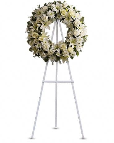Serenity Wreath - A ring of fragrant, bright white blossoms will create a serene display at any funeral or wake. This classic wreath is delivered on an easel, and is a thoughtful expression of sympathy and admiration. A standing wreath created from fresh white flowers such as roses, Asiatic lilies, carnations and cushion spray chrysanthemums - accented with greenery - is delivered on an easel. 