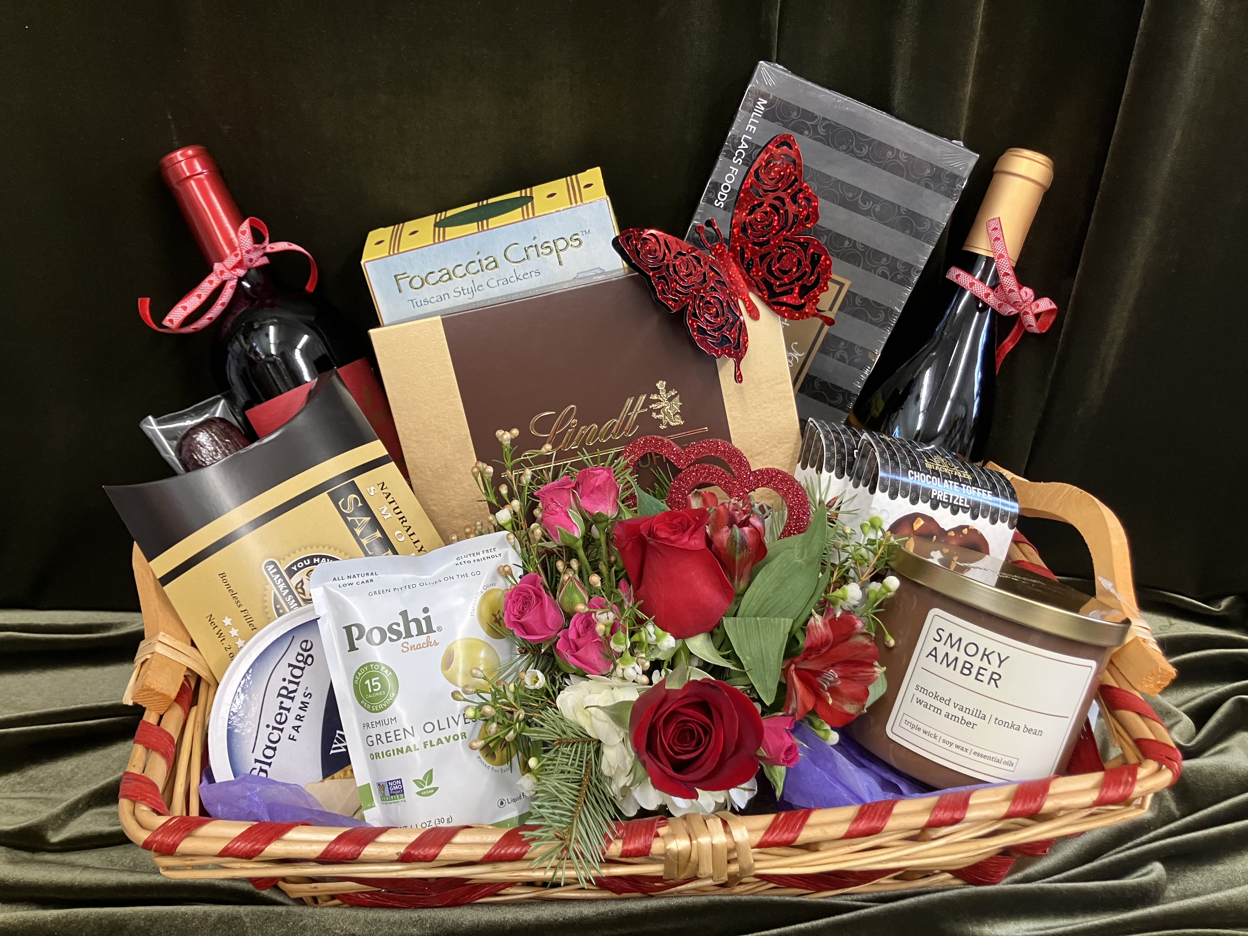 Wine and Snack Gift Basket - Send an outstanding gift basket that includes, two bottles of wine, two cheese options, two meats, salted almonds, crackers, truffles, and a sweet flower arrangement of white daisies and purple roses. Beautiful gift for many occasions 