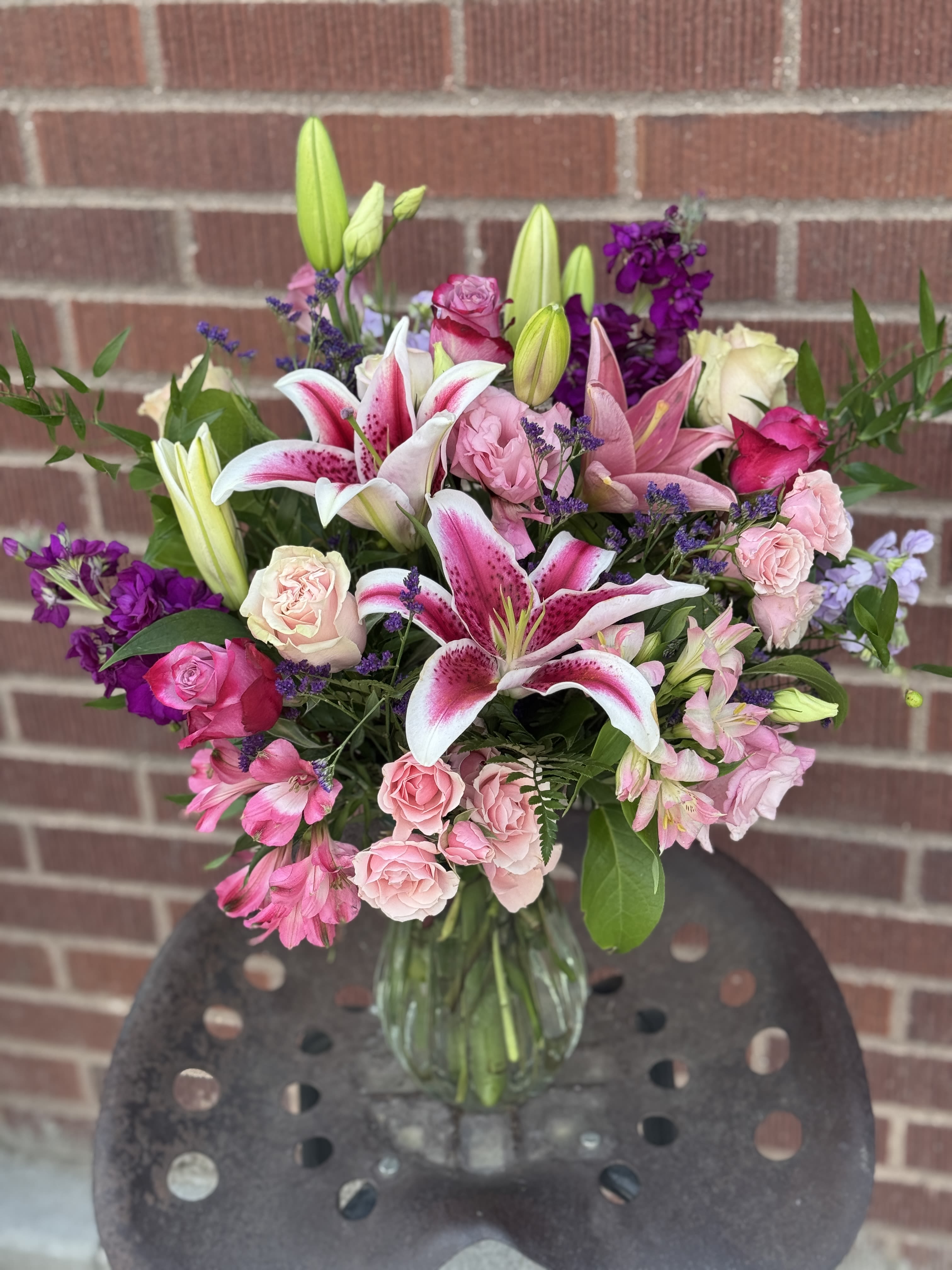 Night &amp; Day - The sunny hues of daytime mingle with the dusky tones of night in this medley of yellow and purple blossoms that will be welcomed at any time, and for any occasion. A unique pairing of colors, and a stunning presentation.