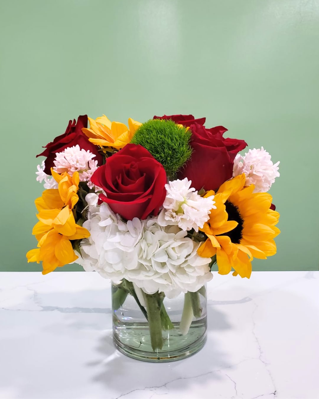 Valentina  - This wonderful, scented arrangement has hydrangeas, roses, sunflowers, dianthus, and hyacinths in a clear cylinder.