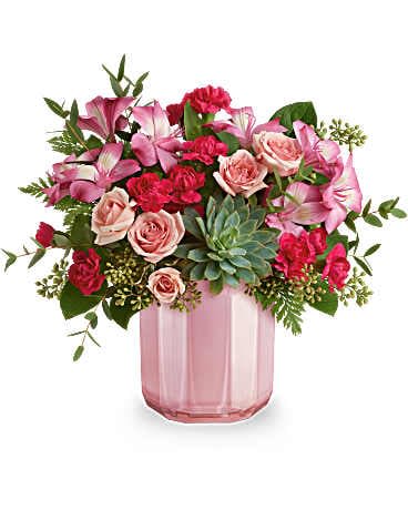 Rosy Radiance Bouquet - Brighten their day with this fabulous Valentine's Day bouquet, featuring a lovely succulent, all elegantly arranged in a pink glass vase with a chic sculpted design and pearlescent finish. This lovely Valentine's Day arrangement showcases an all-pink look with spray roses, alstroemeria, and miniature carnations, beautifully complemented by a succulent, parvifolia eucalyptus, seeded eucalyptus, leatherleaf fern, and lemon leaf. 