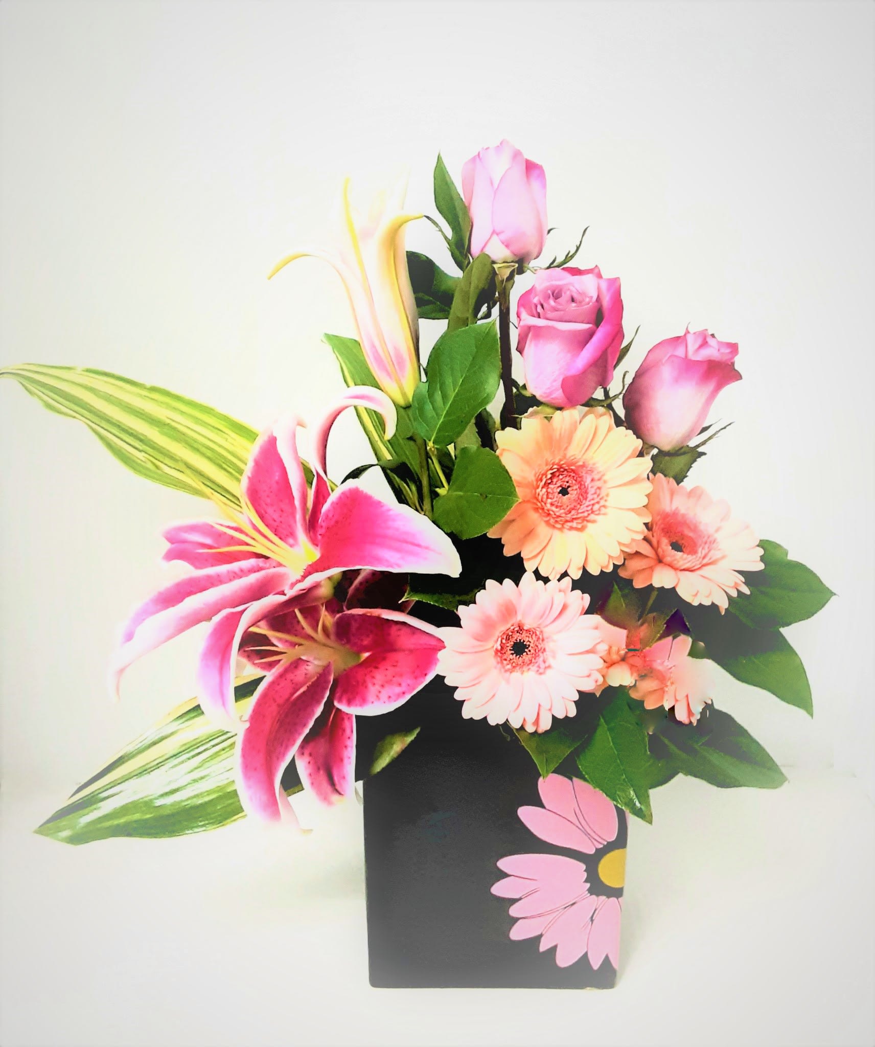 Sophisticated Flair - The perfect keepsake with a modern flair, gerbera daisies,roses,lilies and variegated aspidistra,and accented with lemon leaves