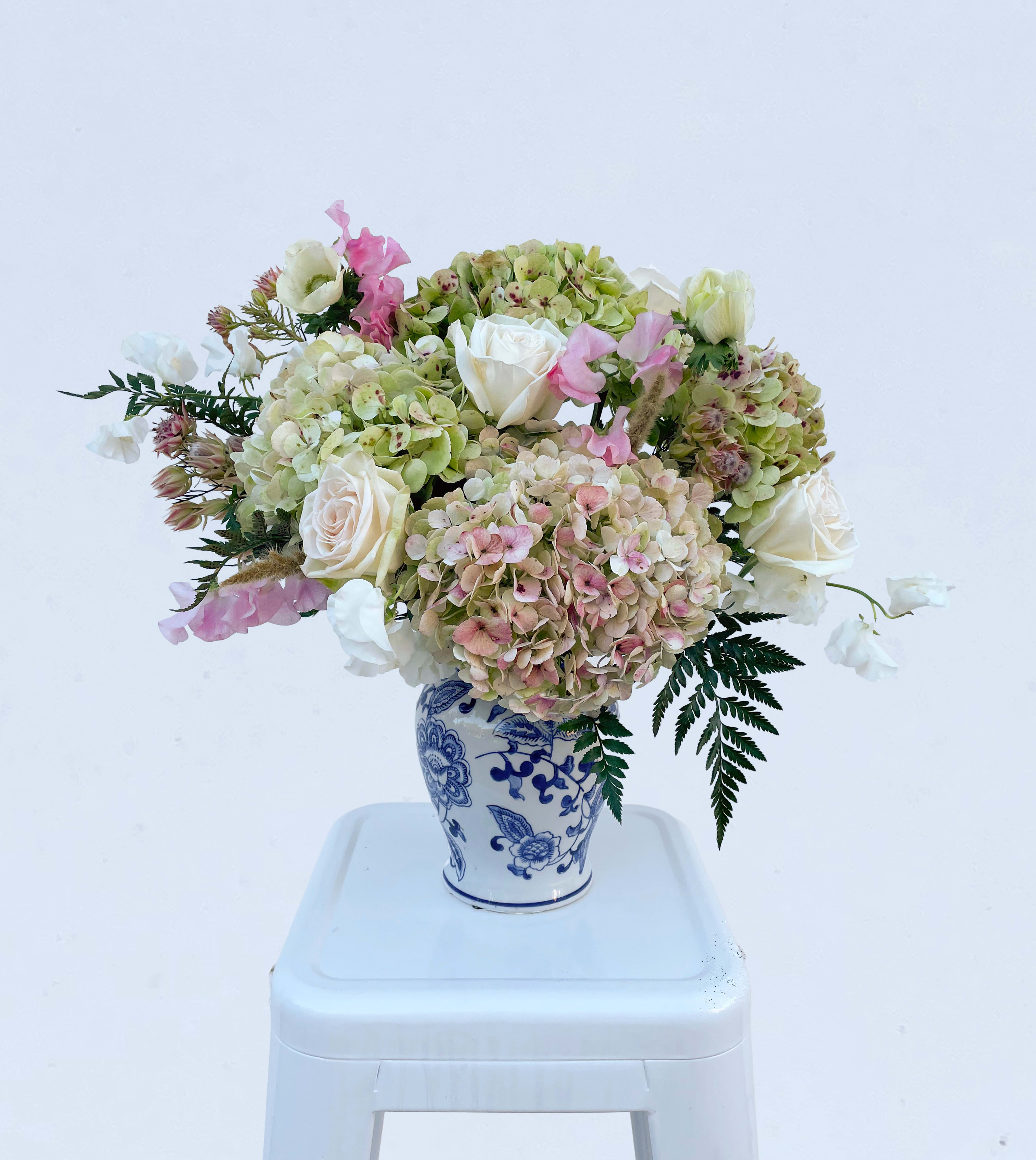 Savannah's Sweetheart - Meet Savannah's Sweetheart—our newest Valentine’s arrangement, designed to charm at first glance. Creamy roses, blush-kissed hydrangeas, and a varying selection of premium blooms, such as ranunculus and sweet peas, are artfully styled in a classic ginger jar vase.  Romantic, polished, and just a little flirty—she’s made to steal hearts.   *** Please note: Vase styles may vary based on availability and will be substituted with a similar design if needed. ***