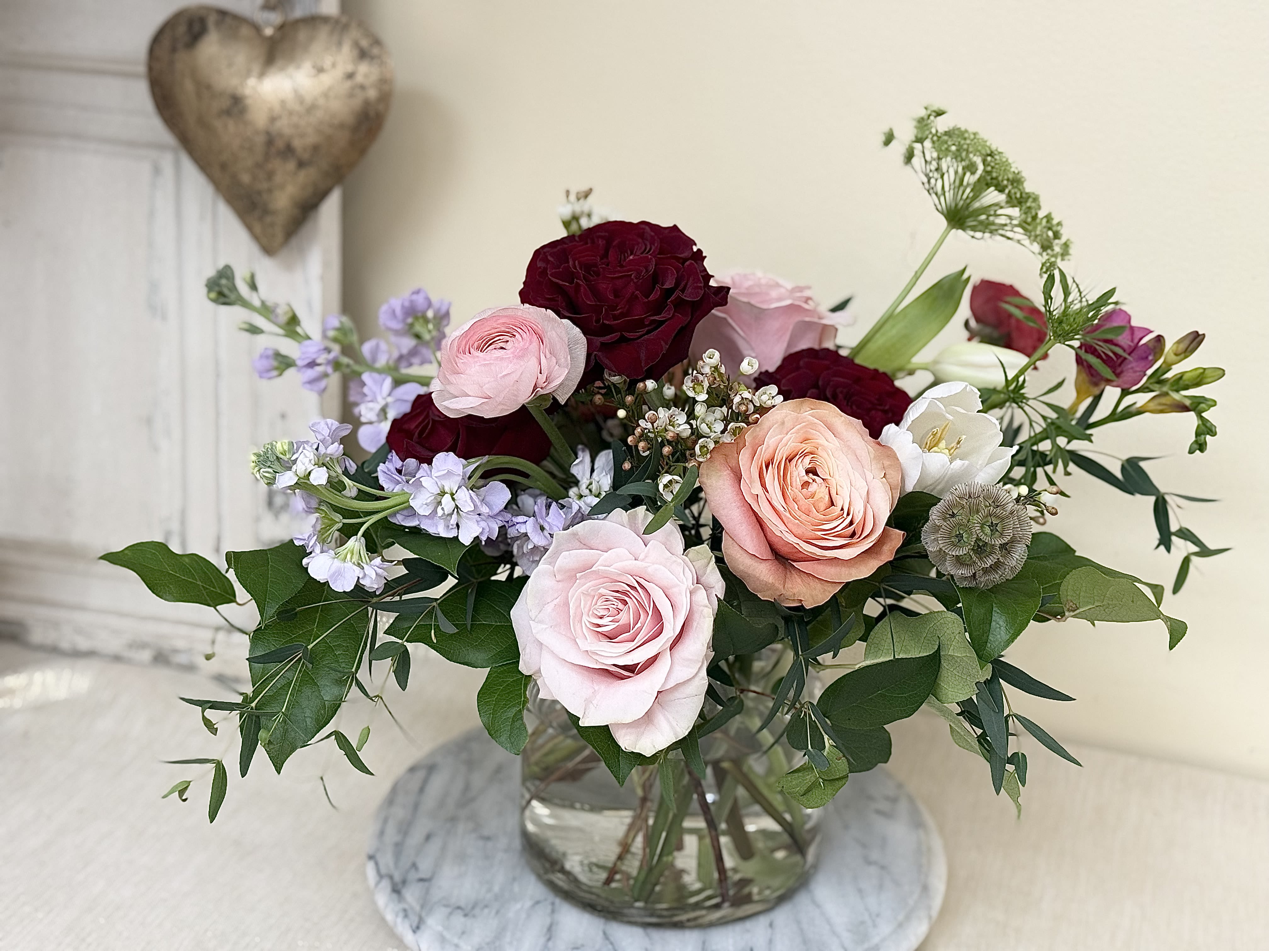 Garden Romance - A beautiful, Romantic garden arrangement for that special person in our lives that love color, we have added the traditional red garden roses to signify the romance but not overwhelm! The gold heart is decoration but can be bought in our cross sells