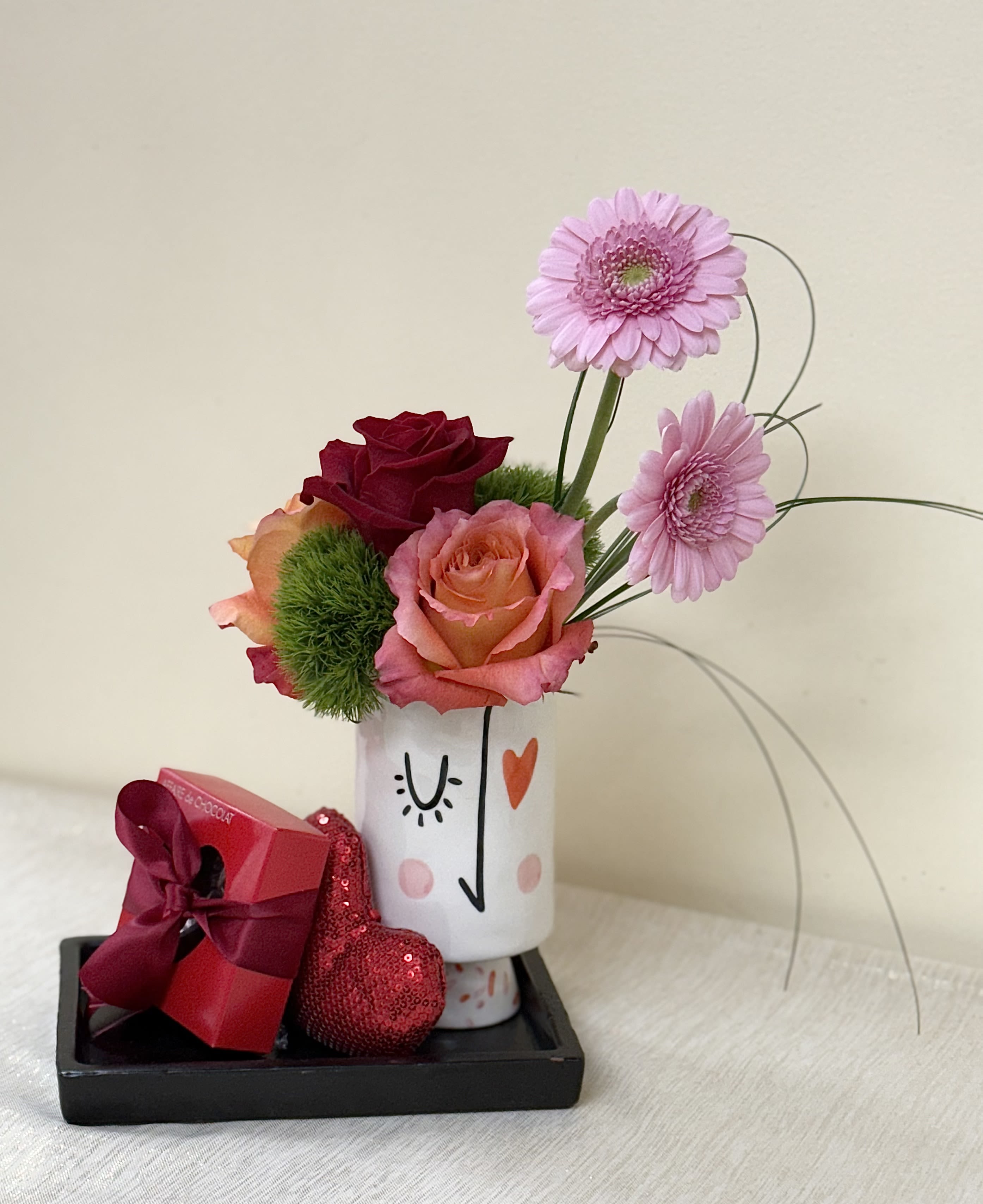 Face of Love - A lovely arrangement and gift for your very special person with a keepsake face vase, beautiful booms and texture make up this this design and can change with the seasons. We also include a presentation ceramic tray, a soft heart and a box of delicious truffles from Local Affaire de Chocolat.