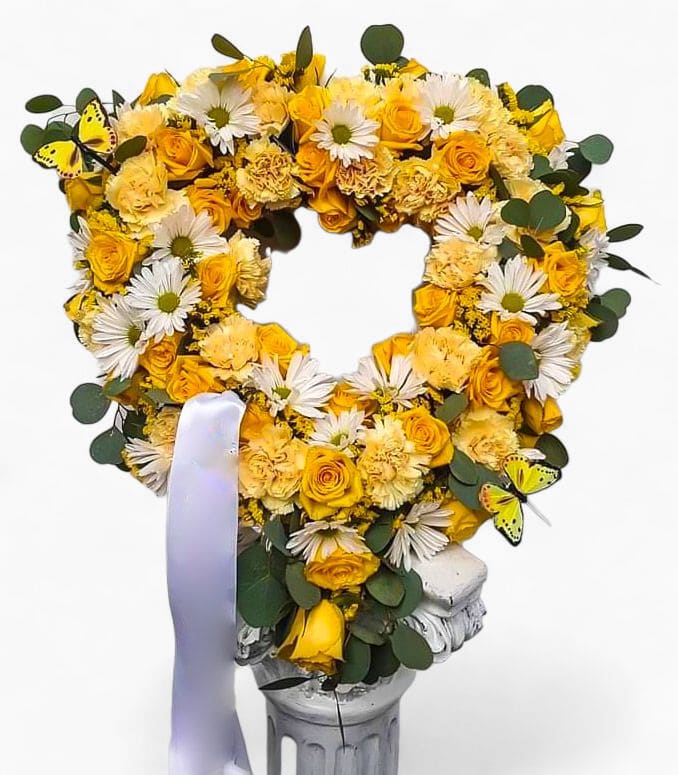 Heavenly Sunshine Heart Wreath - A beautiful tribute in yellow and white seasonal blossoms arranged in a sympathy heart. Premium roses, and more for a uplifting honoring. 
