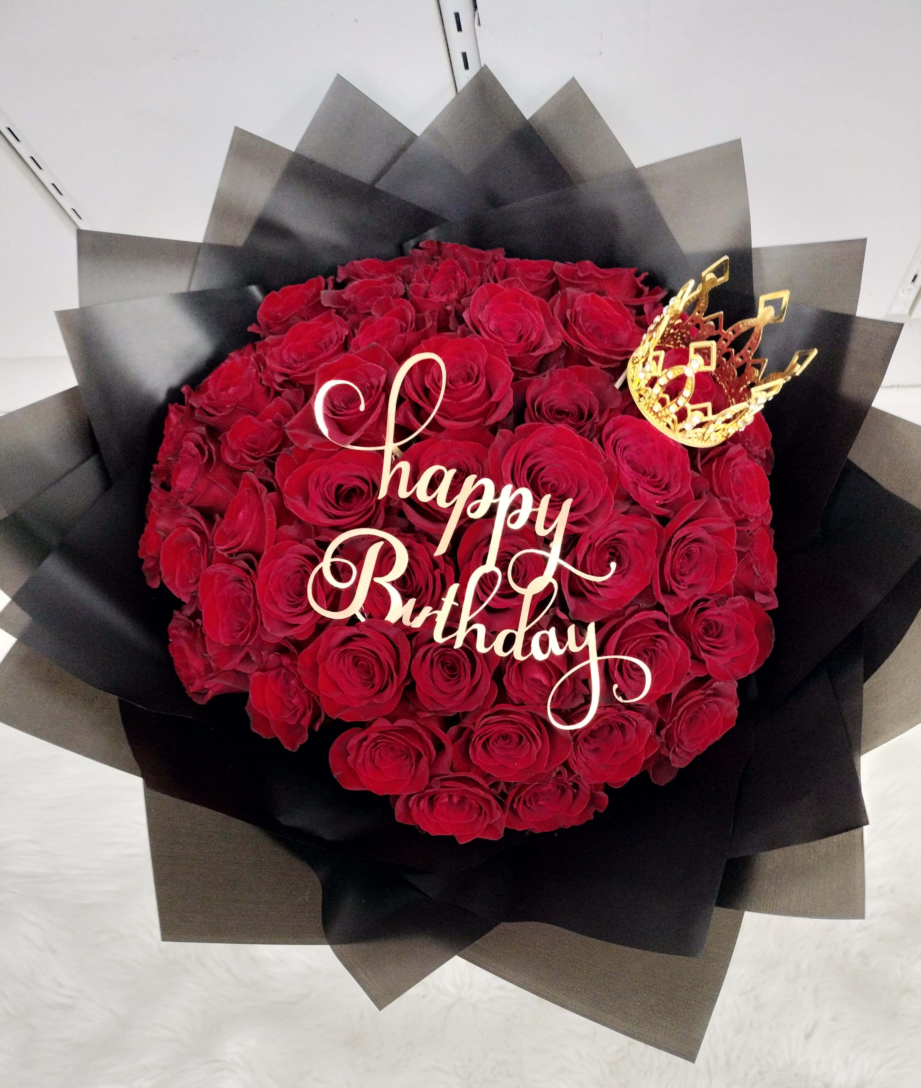 Red Pretty Bouquet - 50 long red roses wrapped in black paper with ribbon, Happy Birthday pick and bow. Crown not included, crown is $20 extra.