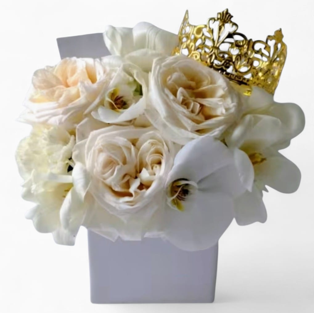 Vanilla Blossoms Beauty Designer's Choice - Send this pretty beauty today to show them that you are thinking of them with it's lovely vanilla blossoms of that day roses orchids and more arranged in a white modern glass vase adorned with a gold crown. Perfect to send today for every occasion. All bouquets are always made extra special and unique each and every time. Please visit my beautiful gallery to see my latest designs that I have created for my online customers. Send them happiness today.