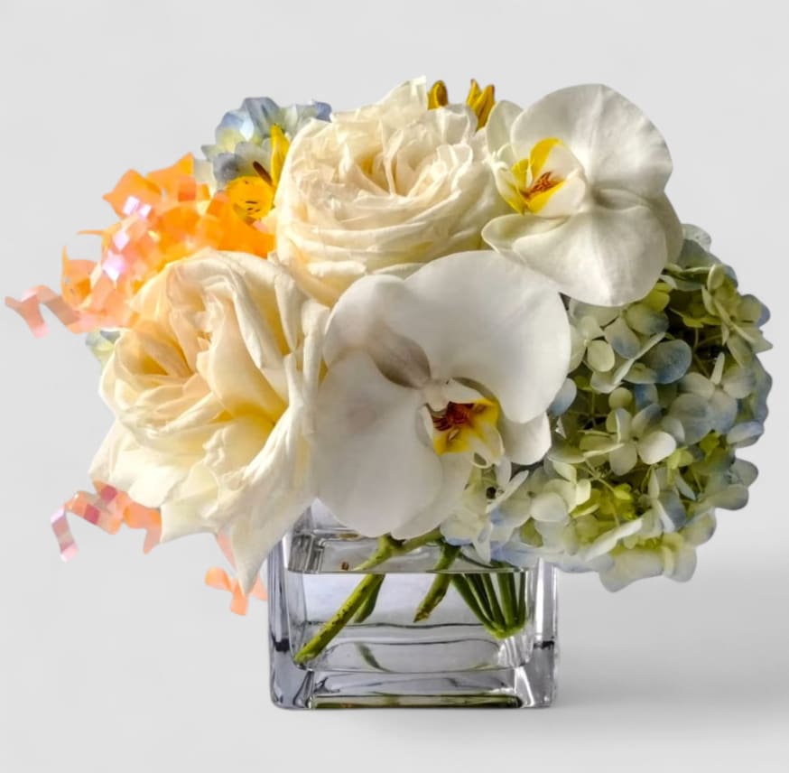 Roses Orchids And Everything Nice Designer's Choice - Roses orchids hydrangeas and more arranged in a modern glass cube vase. Beautiful and perfect to send today to show them how much you care. Always made unique and extra special each time. Send happiness.