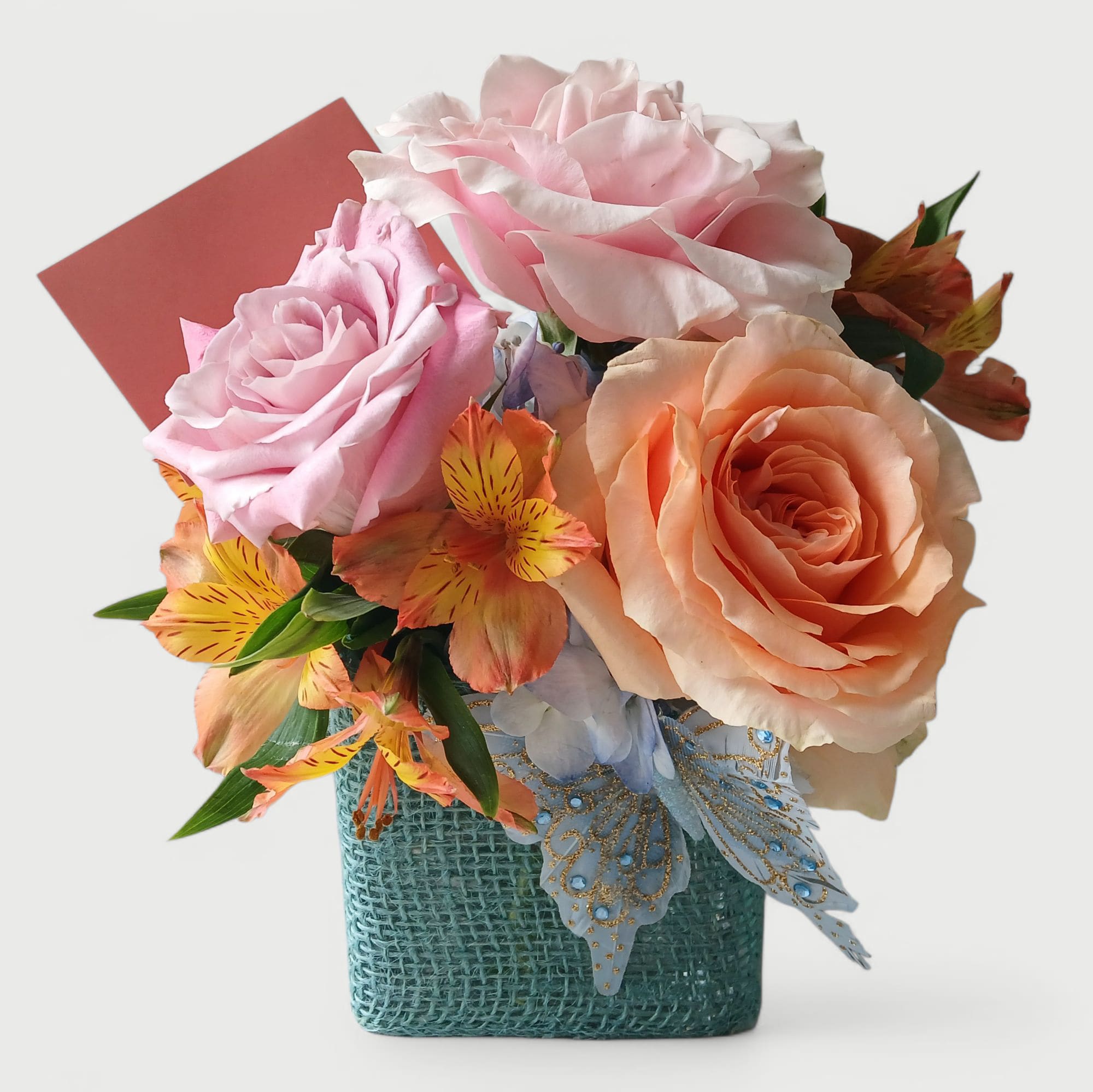 Collingswood Brighten Your Day Flowers - Collingswood sweet size flower bouquet filled with three beautiful colorful roses a hydrangea and more arranged in a pretty blue jute wrapped modern vase with a cheerful sparkly blue butterfly. Perfect to send to brighten their day. All of my designs are always made extra special each time. Send them flowers to make their day.