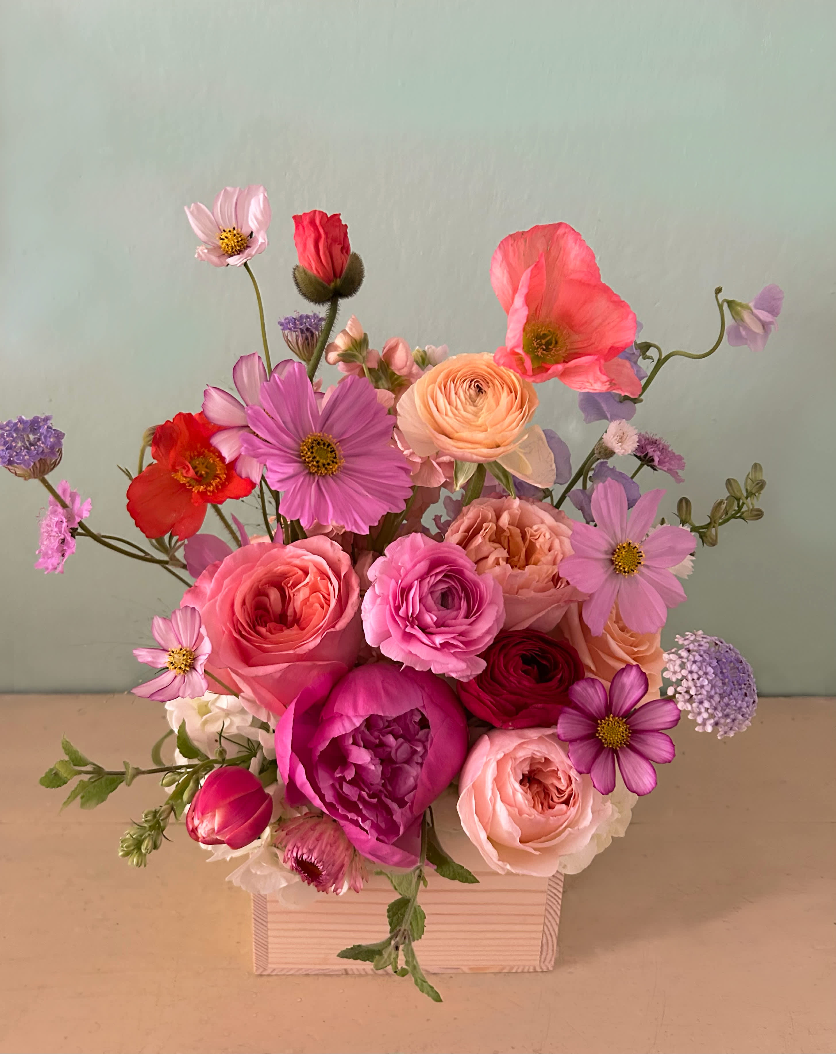 Molly color box - Beautiful box of brigth and happy flowers. With the feel of a flower meadow, ethereal and natural. Stunning happy color palette with selected pretty stems that rise up in this small light wooden box  (6" by 6" and 4" tall) full of garden like stems such as: peonies, sweet peas, ranunculus, roses and seasonal natural flowers. Upgrade to Deluxe or Premium for a fuller and richer arrangement with more stems. Blomst LA only uses fresh, high quality flowers, all carefully selected every day to fit your flower order.  We offer a personal hand delivery by our own delivery staff and guarantee the flowers will look perfect, when they arrive. We deliver in Glendale, Pasadena, Eagle Rock, Hollywood, Burbank, Beverly Hills - and everywhere else in Greater Los Angeles.