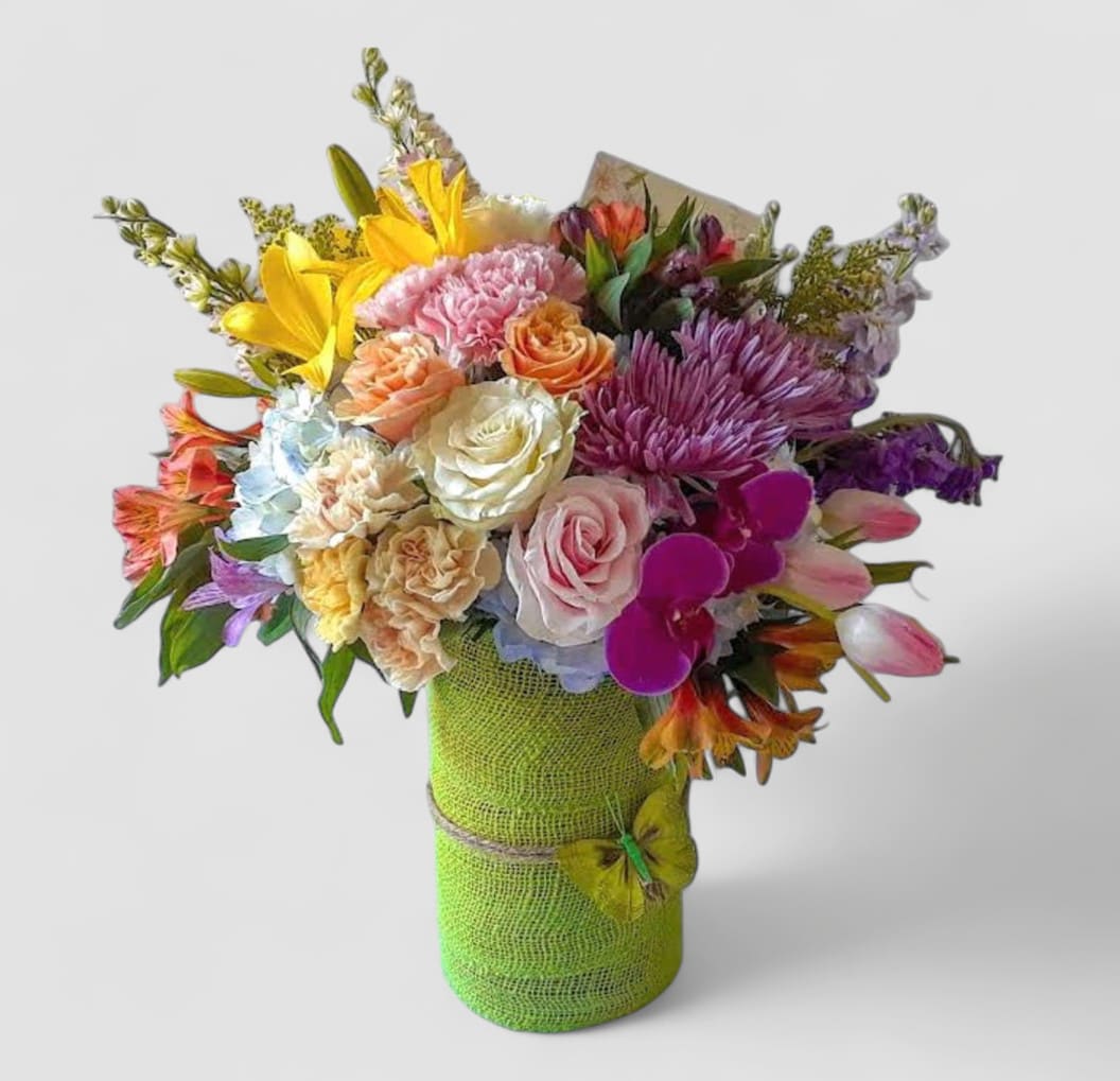 Vibrant Blossoms Designer's Choice - Roses orchids hydrangeas daisies and so much more arranged in a tall modern glass cylinder vase wrapped in pretty citrus green jute ribbon. Beautiful and perfect to send today for every occasion to show them how much you care. All of my bouquets are always made extra special and unique each and every time. Send them happiness.