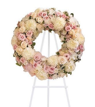 Peace Eternal Wreath - Lovely blooms such as crème and pink roses, pink hydrangea and white chrysanthemums are nestled together and accented with organza ribbon. A touching and feminine wreath, ideal for a memorial service.