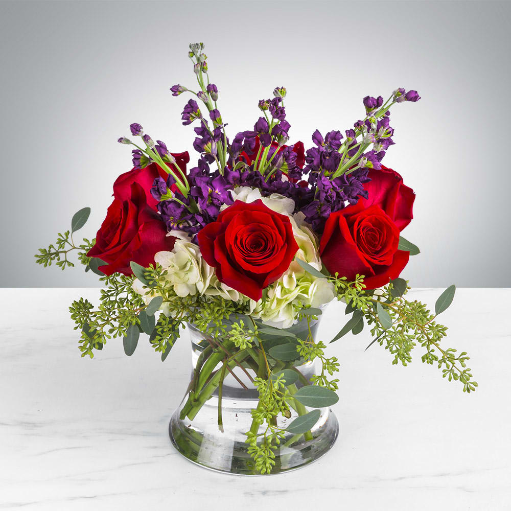 Love at First Sight - This vibrant bouquet will show that special someone how passionate you are about them. Love at First Sight by BloomNation™ is a great gift for Valentine's Day, a birthday, an anniversary, or a romantic gesture.    Arrangement Details: Includes white hydrangea, red roses, purple stock, &amp; seeded eucalyptus.  APPROXIMATE DIMENSIONS: 13"H X 10" W