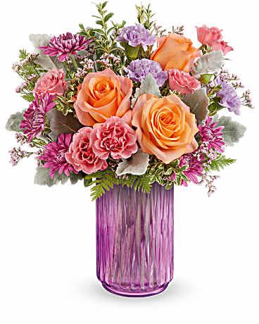 Radiant Joy Bouquet - Illuminate their spring dreams with Teleflora's Radiant Joy Bouquet, featuring a vibrant mix of orange, pink, and lavender, artfully arranged in a striking pink vase that shines with warmth and cheer. Light orange roses, pink spray roses, lavender carnations, and purple cushion spray chrysanthemums come together with pink limonium, dusty miller, leatherleaf fern, and oregonia. This delightful spring arrangement is delivered in Teleflora's Radiant Joy Lantern. Approximately 13 3/4" W x 16 1/2" H