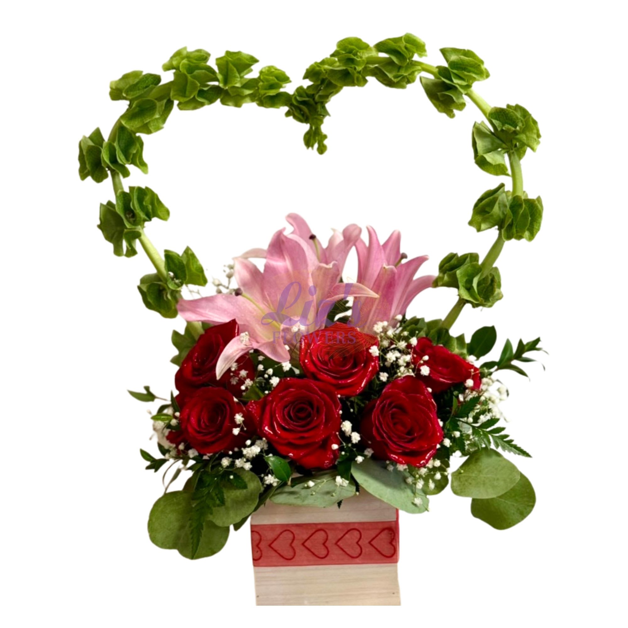 Blushing Heart Bloom - Heart-shaped arrangement of red roses and pink lilies, accented with baby's breath.