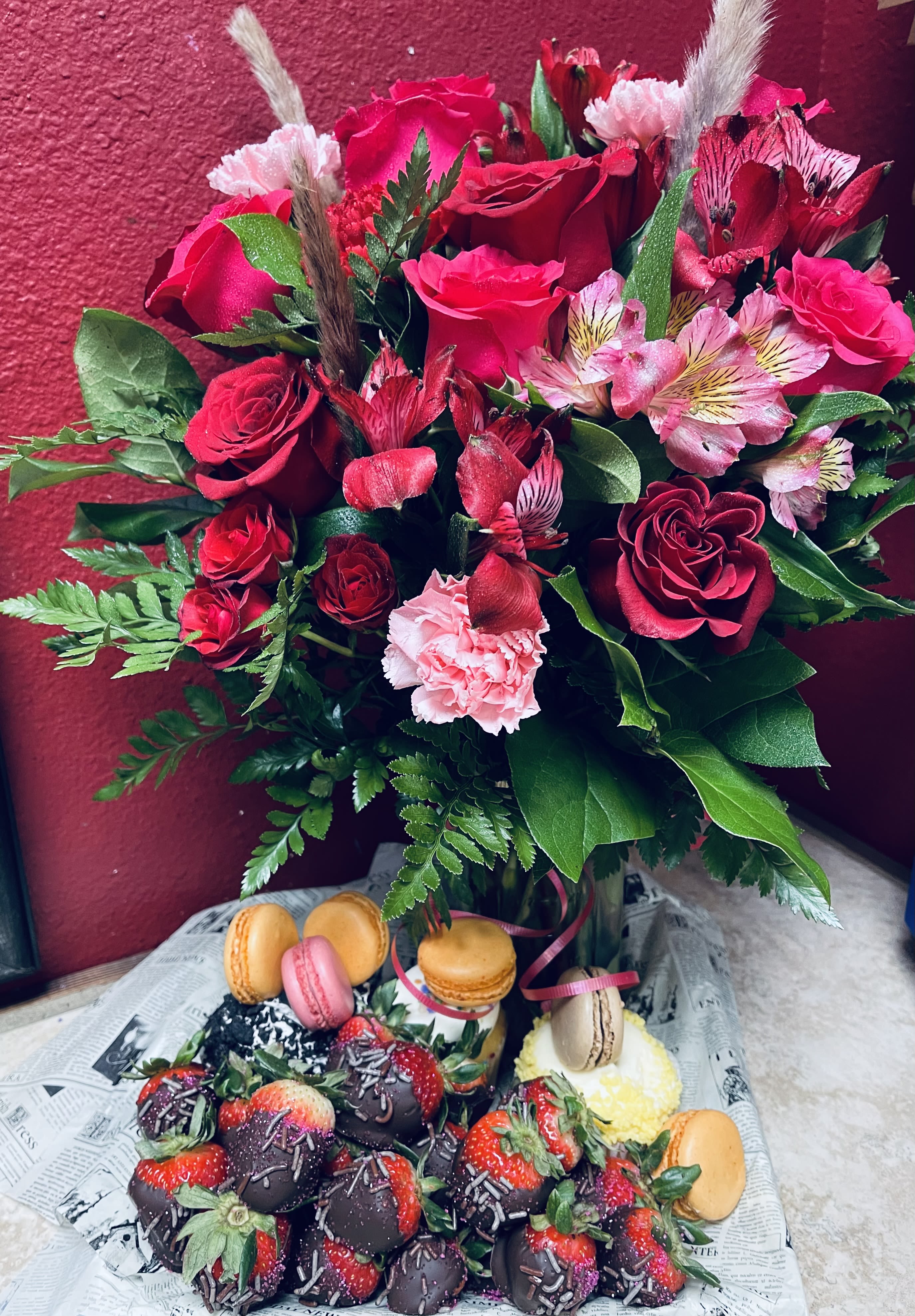 Sweetheart Extravaganza - Celebrate Valentine’s Day in the most unforgettable way. This stunning arrangement features lush red blooms beautifully designed to capture the essence of love, paired with an oversized tray of decadent Valentine’s sweets and treats. Indulge in an irresistible selection of elegant macarons, rich cupcakes, chocolate-covered strawberries, and gourmet confections, all thoughtfully curated to impress. Bold, romantic, and indulgent, Sweetheart Extravaganza is the perfect grand gesture for expressing love, passion, and sweet devotion this Valentine’s Day.