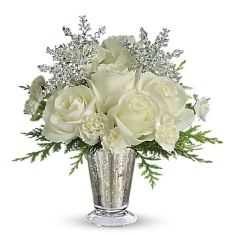 Winter Glow - Sparkling and splendid, this elegant arrangement is perfect for any winter celebration. It makes a spectacular centerpiece, amazing room accent, even an inspired anniversary gift. Especially if it's a silver anniversary! Gorgeous white roses, asiatic lilies and miniature carnations are beautifully arranged with magical silver snowflakes and delivered in a glamorous silver Mercury Glass Vase. Glow ahead and send this stunner today!   Orientation : All-Around  All prices in USD ($)  Standard  T133-1A  Deluxe  T133-1B  Premium  T133-1C