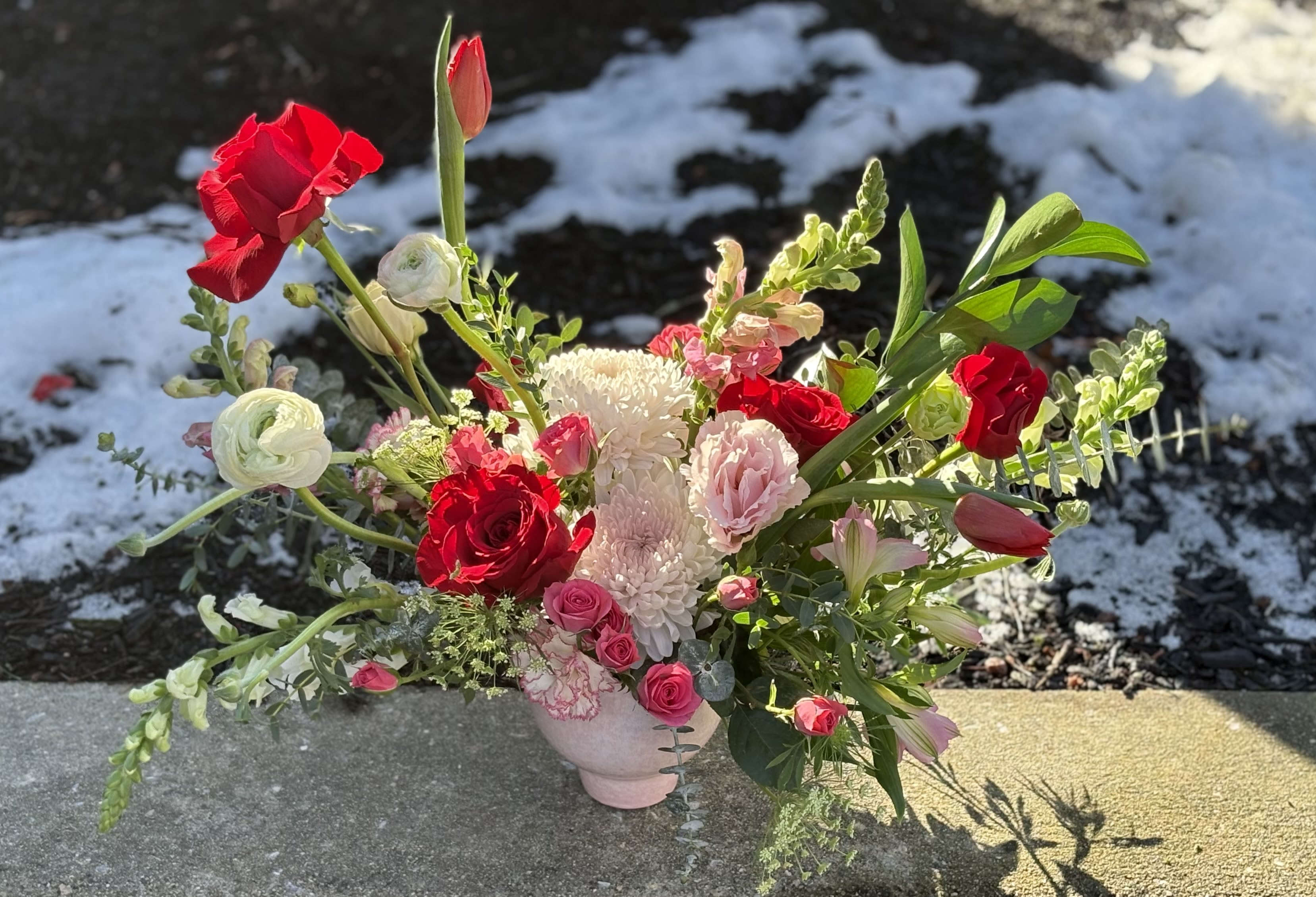 Love’s Modern Garden - Modern garden style arrangement showcases all the high-end favorites for your Valentine….roses, tulips, spray roses, ranunculus, lisianthus and more! Arranged in a short pink ceramic compote. Perfect size for a desk, counter, island or accent table! Standard: as shown. Deluxe: larger with more premium blooms. Premium: includes deluxe arrangement and a 20 piece heart shaped box of chocolates.