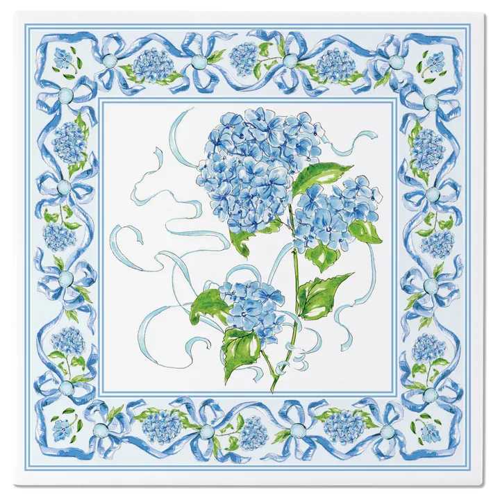 Hydrangea Ribbon Trivet - Awash in watercolor-style blues, the Hydrangea Ribbon Trivet layers graceful hydrangea blooms and flowing bows to bring a fresh floral note to any table. Crafted from durable ceramic, it safely supports hot pots and baking dishes while protecting countertops with effortless charm. Approximate dimensions are 8 x 8 x .25 inches.
