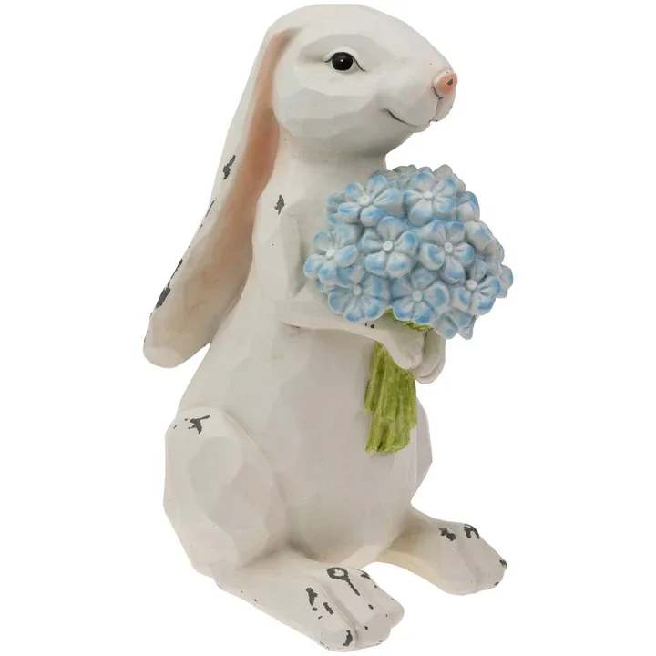 Nibbles Bunny With Blue Hydrangea - Nibbles Bunny With Blue Hydrangea captures a tender moment in sculpted resin, featuring a faceted, lightly distressed look and painted blue blooms for soft color. Perched on a shelf or tabletop, this whimsical figurine brings gentle charm and floral cheer to any room. Approximate dimensions are 6 x 5 x 10 inches.