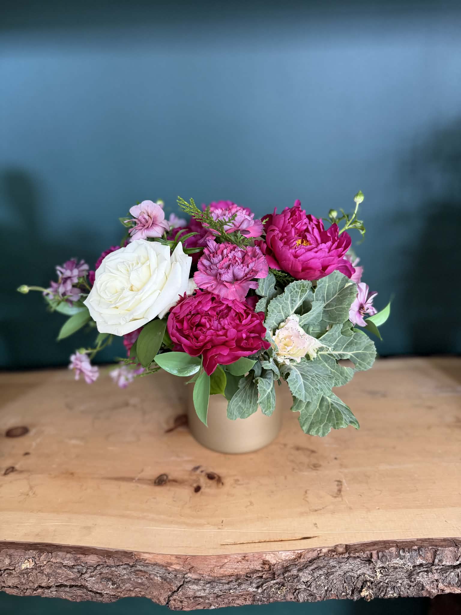 Raspberry Blush - A lush, romantic arrangement featuring rich raspberry and soft blush blooms, thoughtfully layered with creamy whites and seasonal textural greens. Designed in a modern matte gold vessel, Raspberry Blush feels both timeless and indulgent — perfect for celebrations, heartfelt gifts, or simply elevating everyday moments.  Flower varieties may vary slightly based on seasonal availability, while maintaining the signature color palette and overall style.