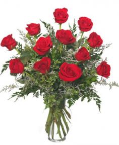 Classic Dozen Red Roses - A dozen of red roses beautifully arranged in a clear  glass vase.   8" classic urn vase   foliage: leather leaf, myrtle    12 red roses    2 stems 'Misty Blue' Limonium
