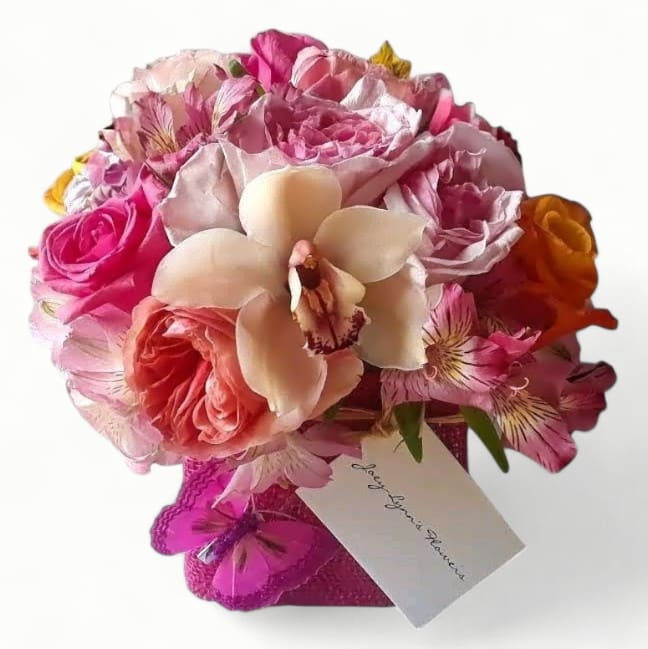 Pretty In Pinks Bouquet - Send this pretty pink bouquet today to make their day. Roses and more arranged in  modern glass cube vase wrapped in pink jute ribbon. Send happiness.