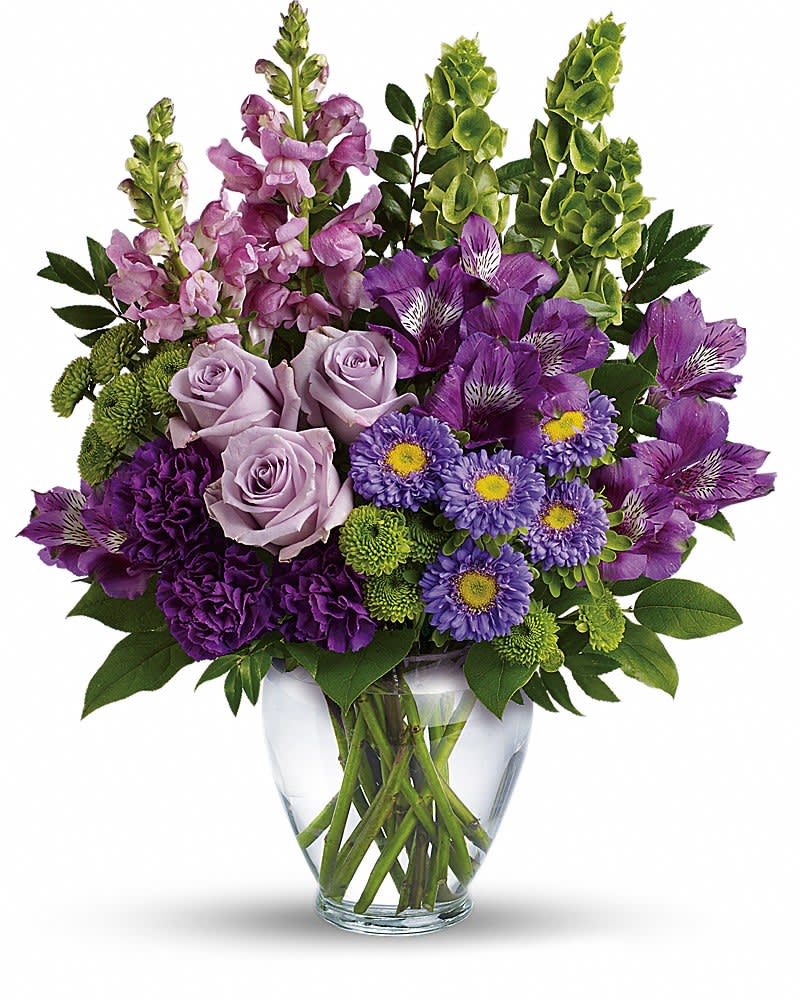 Lavender Charm Bouquet - A soothing sea of lavender, this beautiful bouquet blends luxurious roses and alstroemeria with playful snapdragons and bells of Ireland. It's a charming, cheerful gift for any occasion! This lovely bouquet features lavender roses, purple alstroemeria, purple carnations, lavender matsumoto asters, green button spray chrysanthemums, lavender snapdragons, bells of Ireland, huckleberry and lemon leaf. Delivered in a clear glass vase.