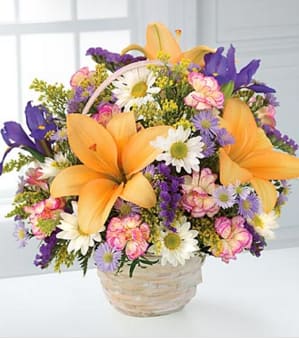 The Natural Wonders™ Bouquet by FTD® - BASKET INCLUDED - This garden bouquet displays the bright colors of nature. Arrangement includes orange lilies, purple iris, and dainty white daisies, with pink mini carnations and yellow solidago. All are designed in a whitewash handled basket. (Iris may be substituted according to seasons.) GOOD bouquet is approximately 12"H x 11"W. BETTER bouquet is approximately 13"H x 12"W. BEST bouquet is approximately 15"H x 14"W. Lilies may arrive in various stages of development. The lily blooms will continue to open, extending arrangement life - and your recipient's enjoyment. Your purchase includes a complimentary personalized gift message.