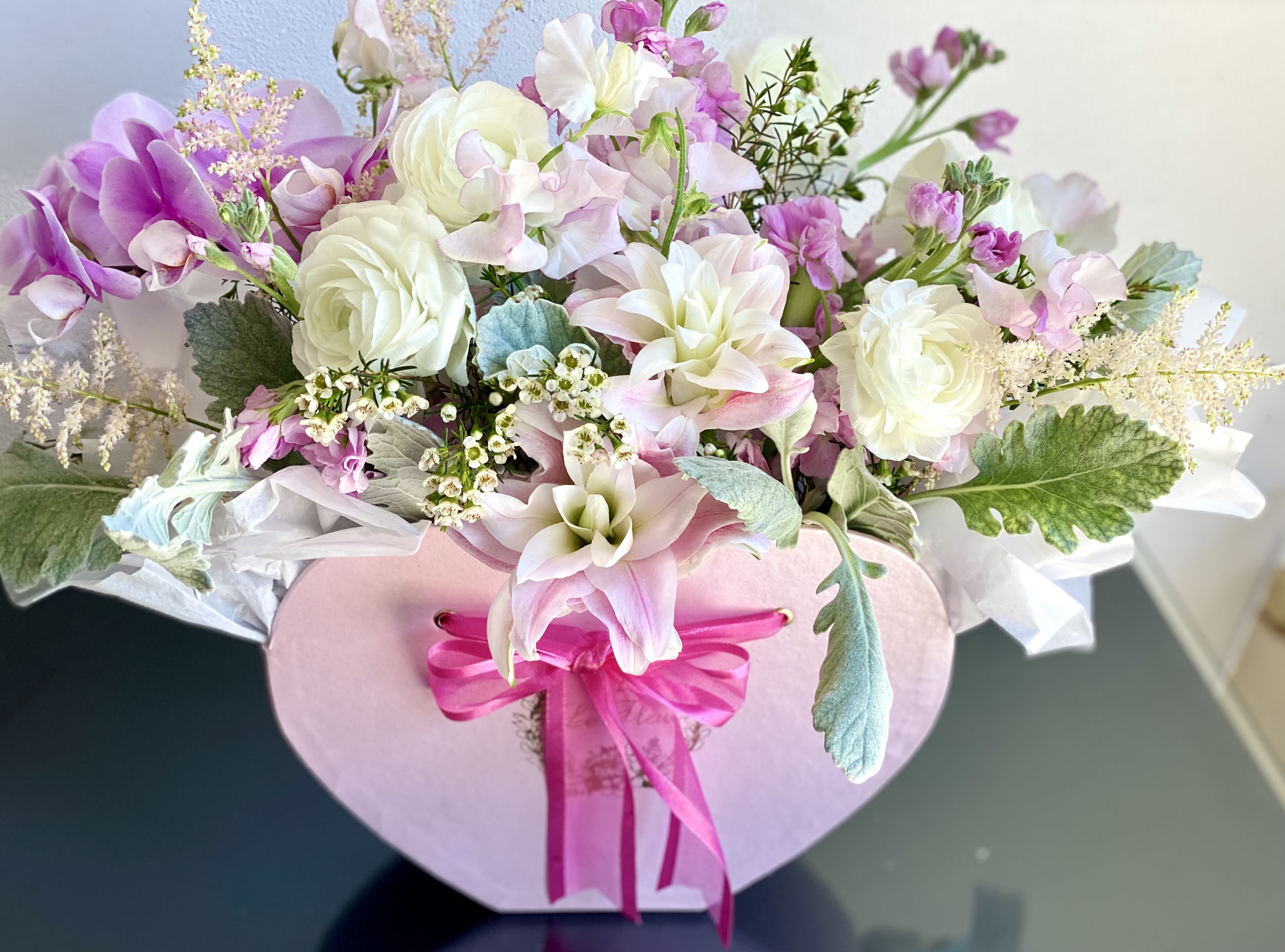 From The Heart - Enjoy our heart shaped floral box overflowing with premium blooms such as ranunculus, rose lilies, stock, scabioza, peonies (when available), etc. Harmoniously arranged to showcase their beauty. Perfect for making a statement of love, romance or appreciation. Blooms might vary based on season.