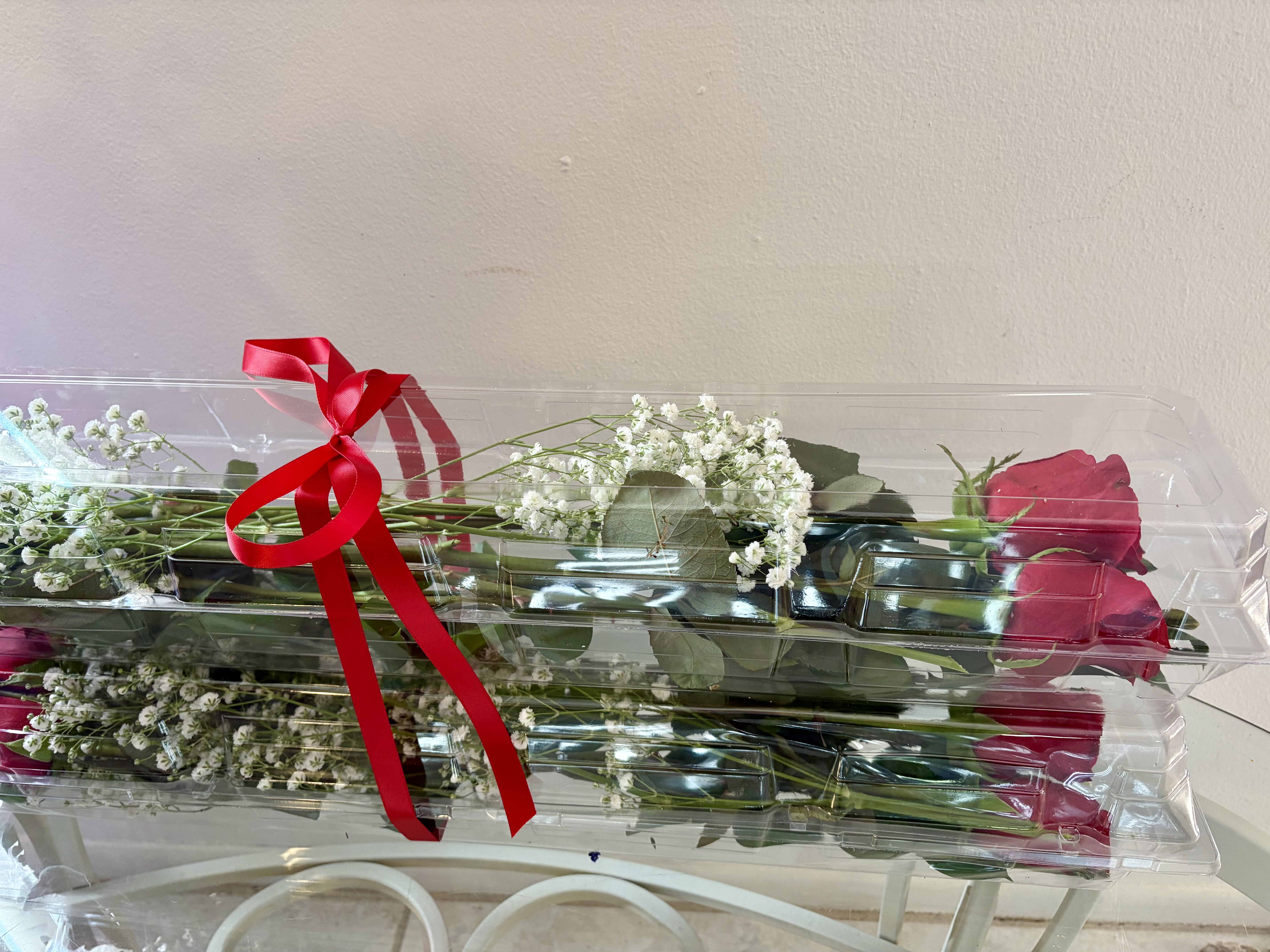 Boxed Red Roses - Premium red roses beautifully presented in a clear box with fresh filler flowers and greenery. Available in half dozen or one dozen options for a timeless, elegant gift.