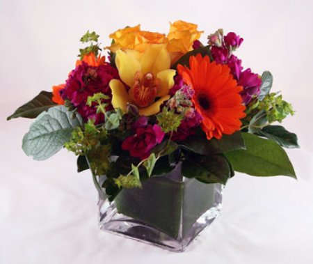 Simply Gorgeous - The name says it all! A simply gorgeous blend of warm-toned blooms  arranged into a vase with mixed greenery.