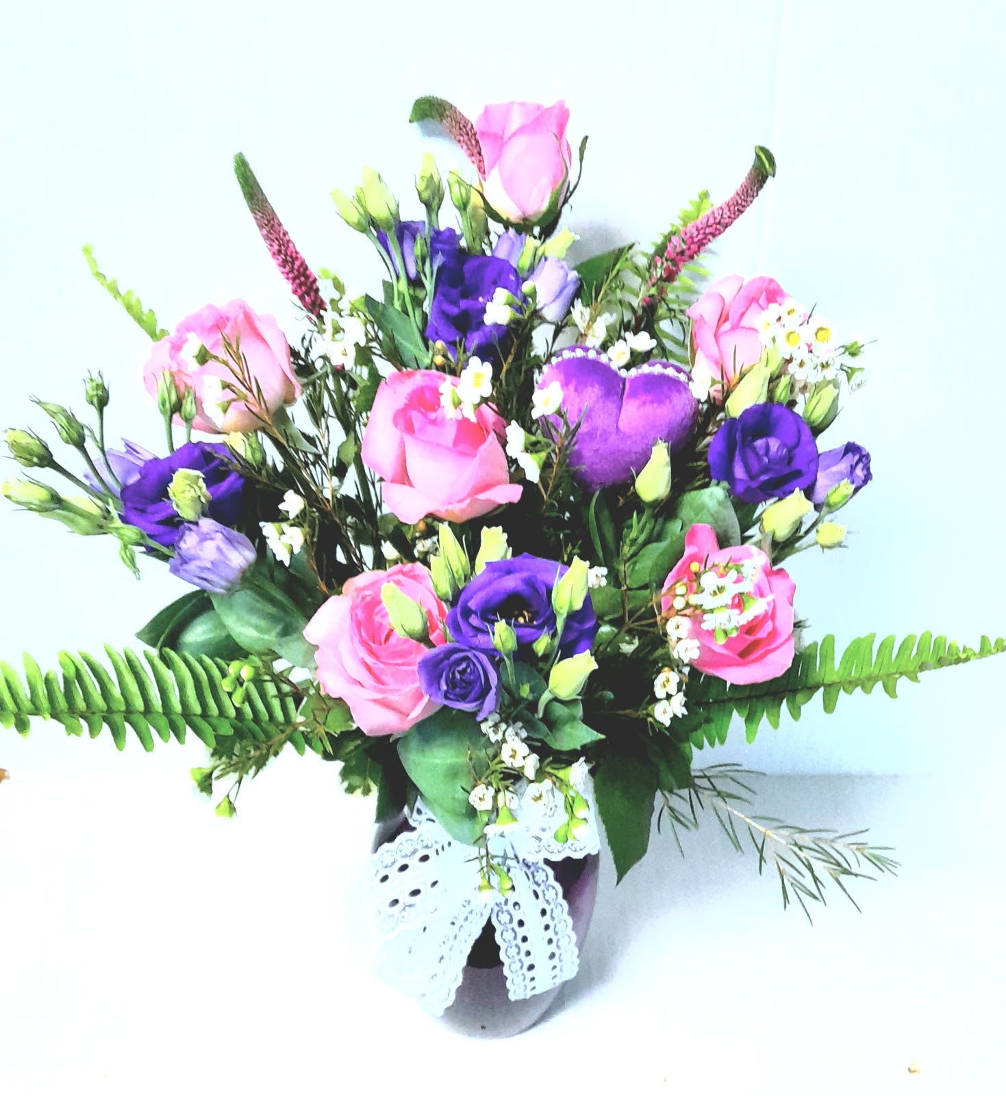 Pink and Purple Lace - Pink roses, purple lisianthus ,sweet fillers and a purple heart in a purple glass vase, with lace accents, just right for the purple lover in your life