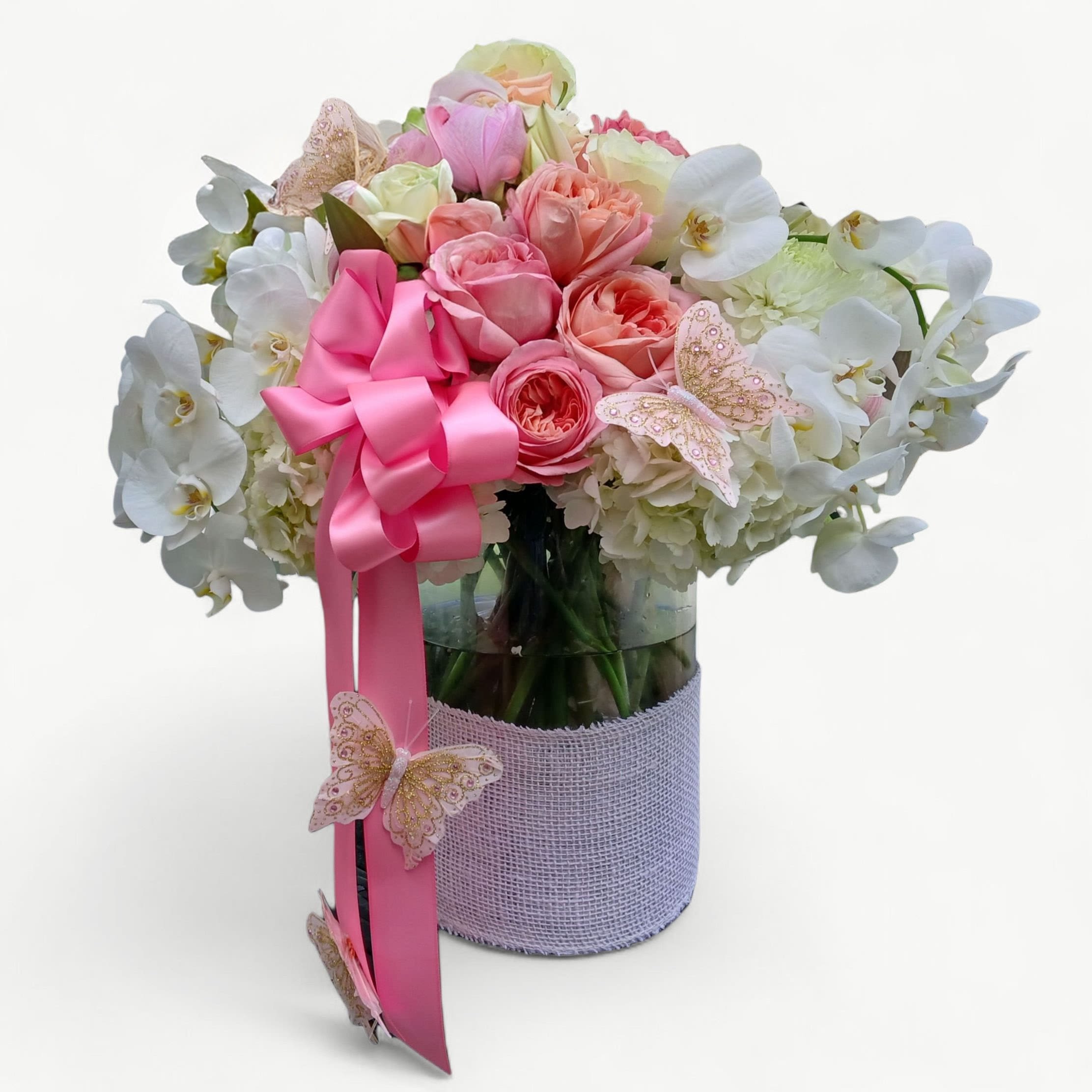 Pink White Bouquet Designer's Choice - Beautiful and filled with pink and white roses hydrangeas orchids lilies and more arranged in a tall modern glass cylinder vase wrapped in white jute ribbon adorned with a pink satin bow. Perfect to send today to show them how much you care. Always made extra special and unique each time. Send them happiness.