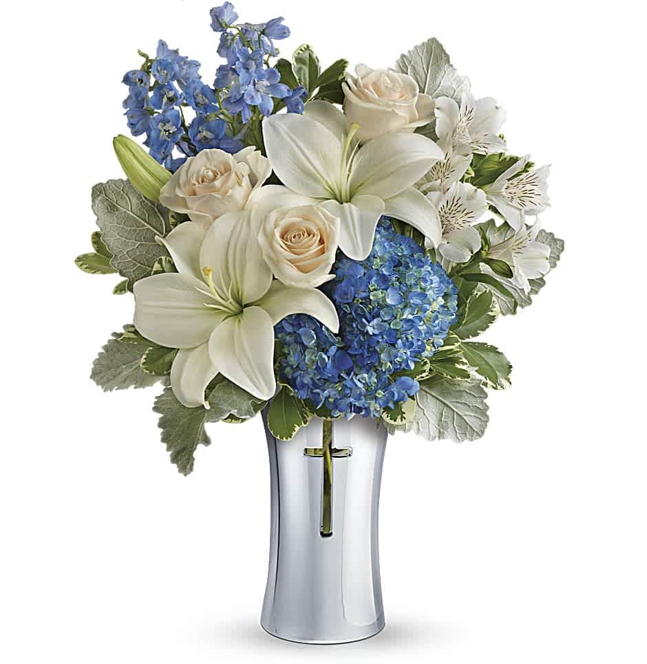 Skies Of Remembrance Bouquet - An elegant expression of your deepest condolences, this majestic mix of blue hydrangea and white lilies will refresh and rejuvenate their spirits. It's hand-delivered in a shining, silver-finished ceramic vase with cross cut-out - a serene, spiritual keepsake they'll always treasure.