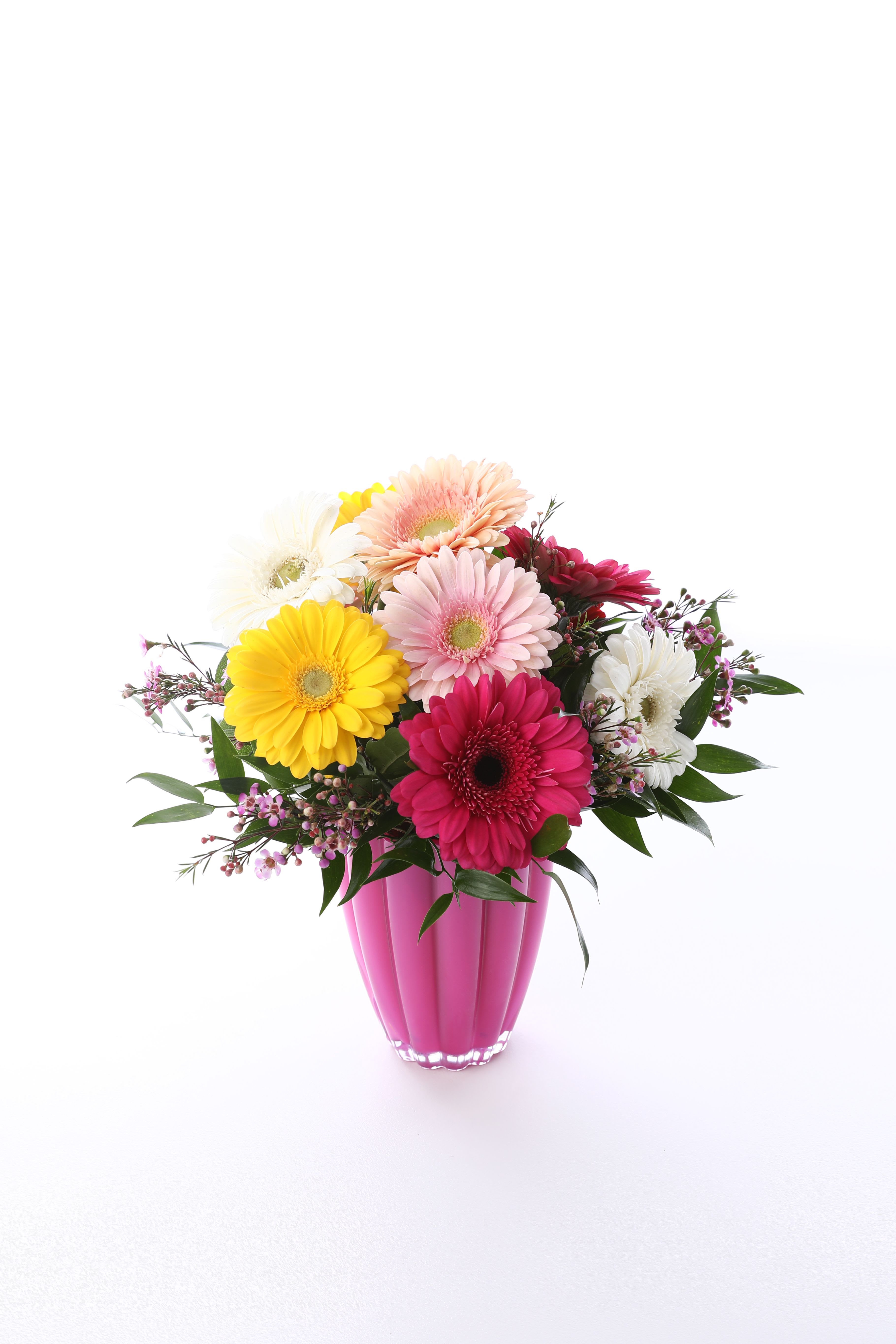 DELIGHTFUL DAISYS - WE TOOK AN ASSORTMENT OF GERBERA DAISYS WITH A LITTLE GREENERY AND SHOWCASED THEM IN A HOT PINK GLASS VASE. 