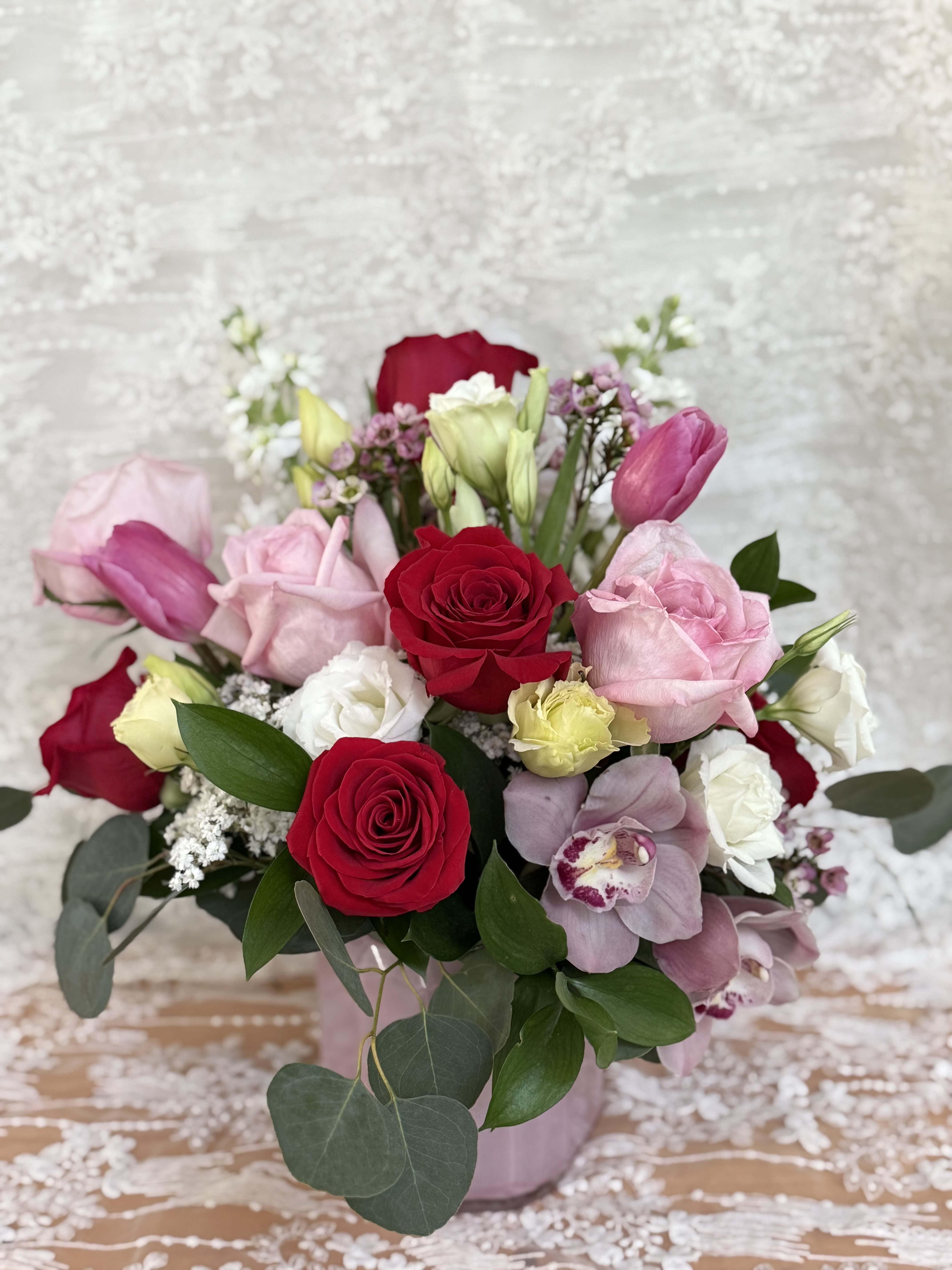 Rose Quartz - Lux arrangement with Tulips, Orchids, Roses, Lisianthus, wax flower stock flower with seasonal greens 