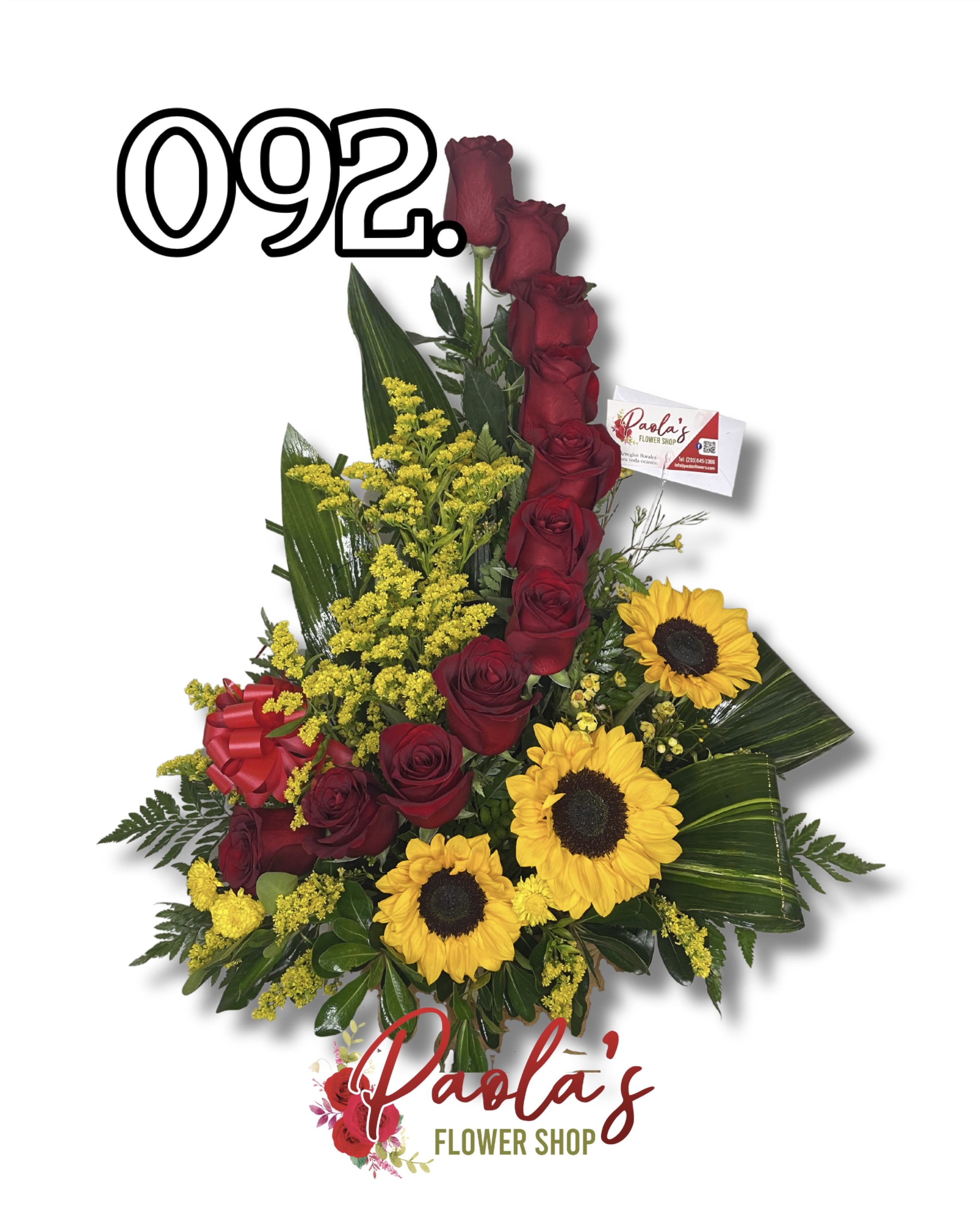 Golden Love Tribute - The Golden Love Tribute is a striking and heartfelt arrangement designed to make a lasting impression. Featuring rich red roses arranged vertically to symbolize deep love and respect, complemented by vibrant sunflowers representing warmth and admiration. Accented with yellow solidago, lush tropical greens, and classic foliage, this arrangement is perfect for expressions of love, gratitude, congratulations, or meaningful tributes. Designed in a fresh floral base for a bold and elegant presentation.