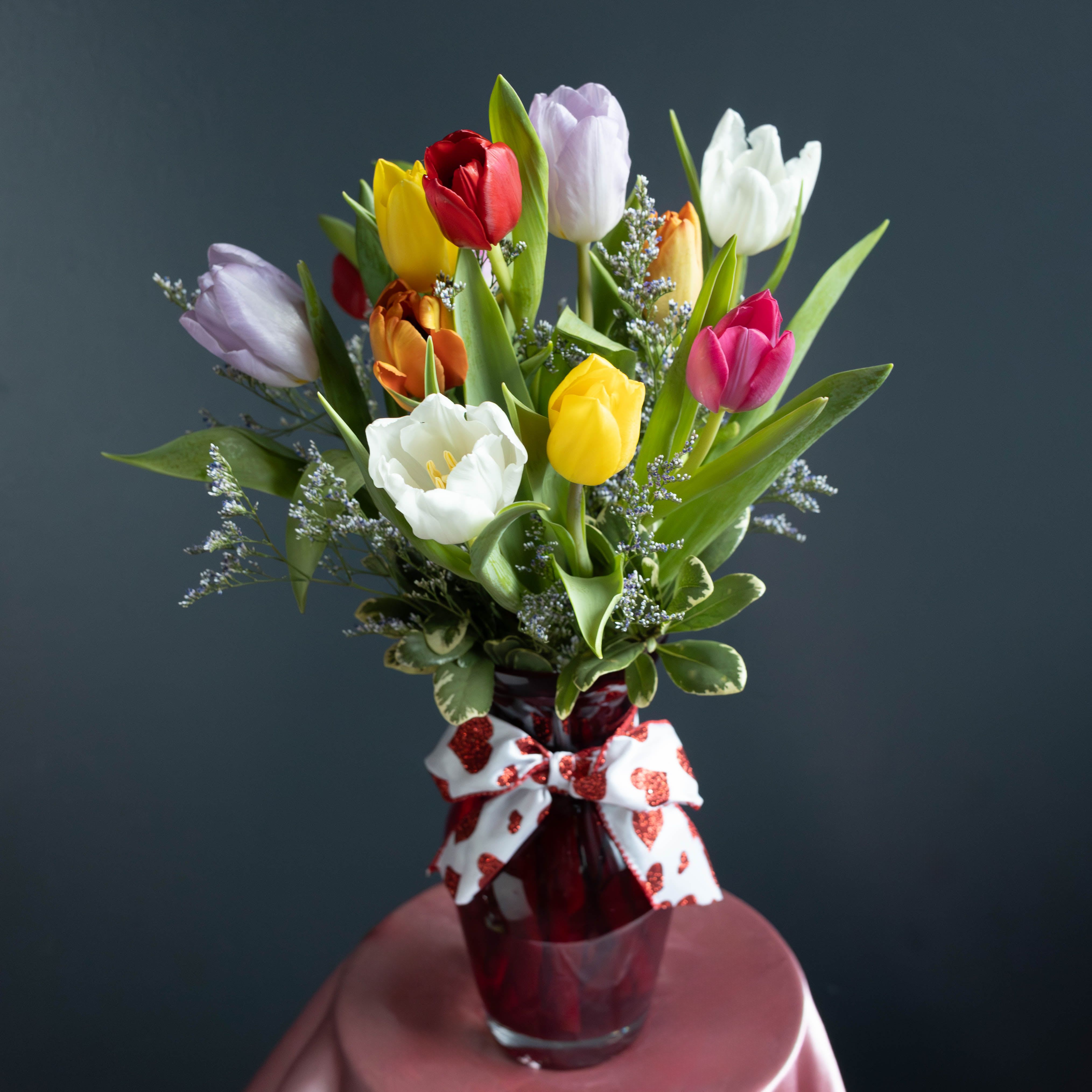 Valentine's Dozen Mixed Tulips - Celebrate love in full bloom with our Valentine’s Dozen Mixed Tulips arrangement, a stunning assortment of one dozen tulips in a vibrant variety of colors. Each stem is carefully selected for its freshness and graceful form, creating a bouquet that feels joyful, elegant, and effortlessly romantic.  Tulips symbolize perfect love and new beginnings, making this arrangement a meaningful way to express your feelings on Valentine’s Day. With a blend of soft pastels and rich, bold hues, this bouquet is ideal for a partner, spouse, best friend, or anyone who brings color and happiness into your life.  Simple yet striking, tulips are a timeless gesture that lets the beauty of the blooms speak straight from the heart.