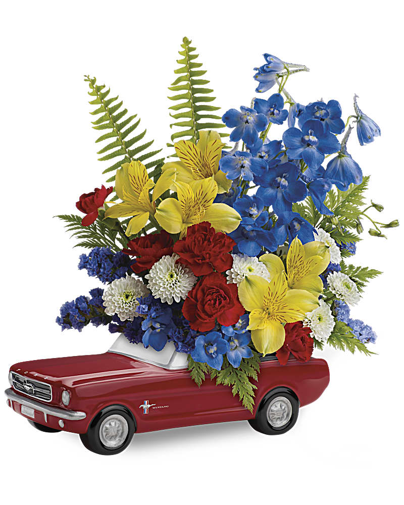 '65 Ford Mustang Bouquet - Celebrate his special day with a true classic! This '65 Ford Mustang in classic poppy red with a bold bouquet is a one-of-a-kind collectible gift he'll always treasure. This bright bouquet features yellow alstroemeria, red miniature carnations, white button spray chrysanthemums, blue delphinium, blue sinuata statice, leatherleaf fern and sword fern. Delivered in Teleflora's exclusive '65 Ford Mustang collectible keepsake.