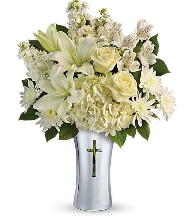 TF Shining Spirit Bouquet - A shining tribute to a life well lived, this pure white bouquet of hydrangeas, roses and lilies is arranged in a beautiful ceramic vase with gleaming metallized finish and reverent cross cut-out. Please give us a call or specify if you would like different colors.