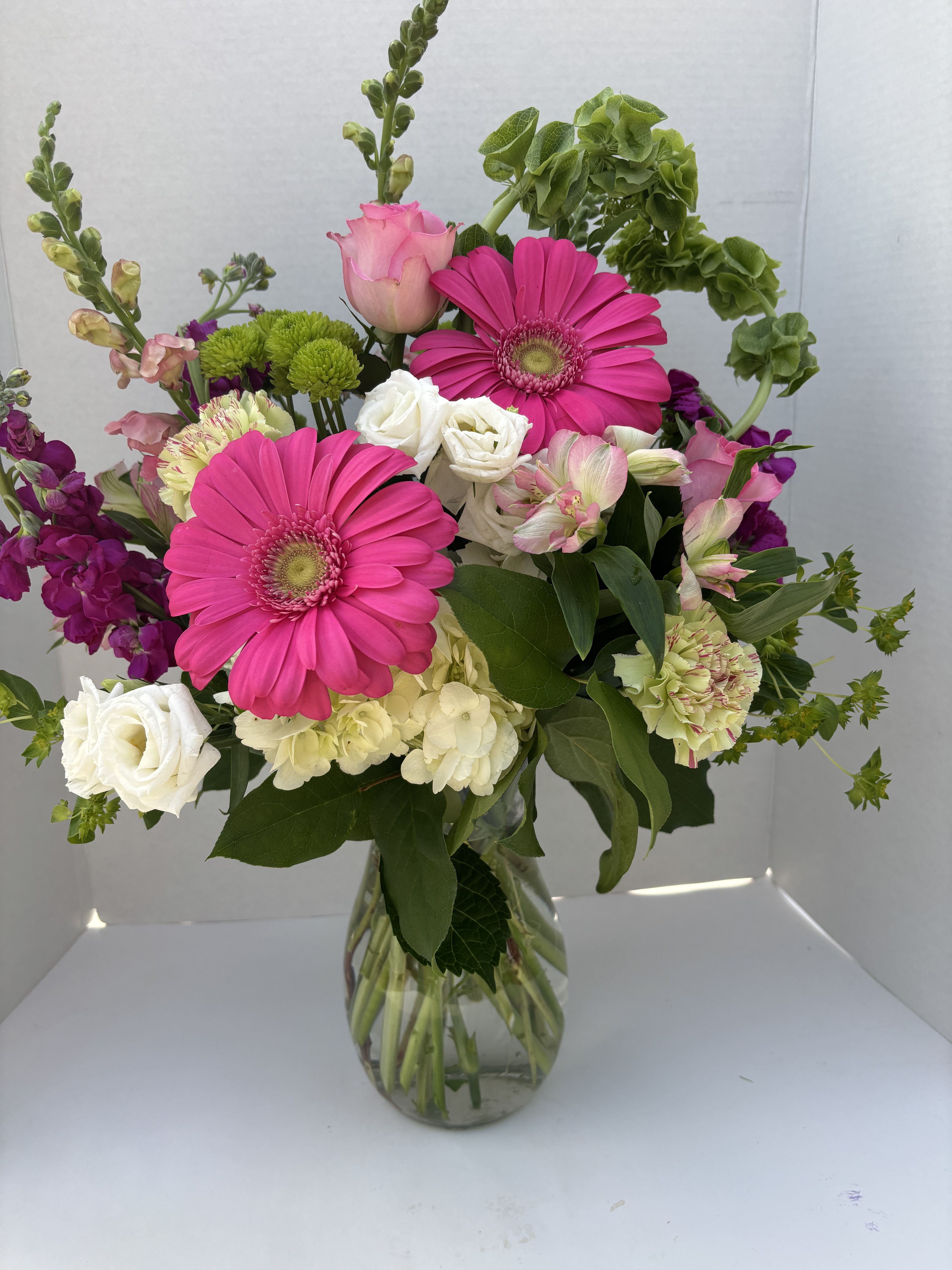Kisses, Kisses, Kisses - All the best shades of lipstick represented in this bright, fun arrangement.  Roses, carnations and gerbera daisies in pinks and reds are accented with stock, snap dragons, hydrangea and mixed greens.  