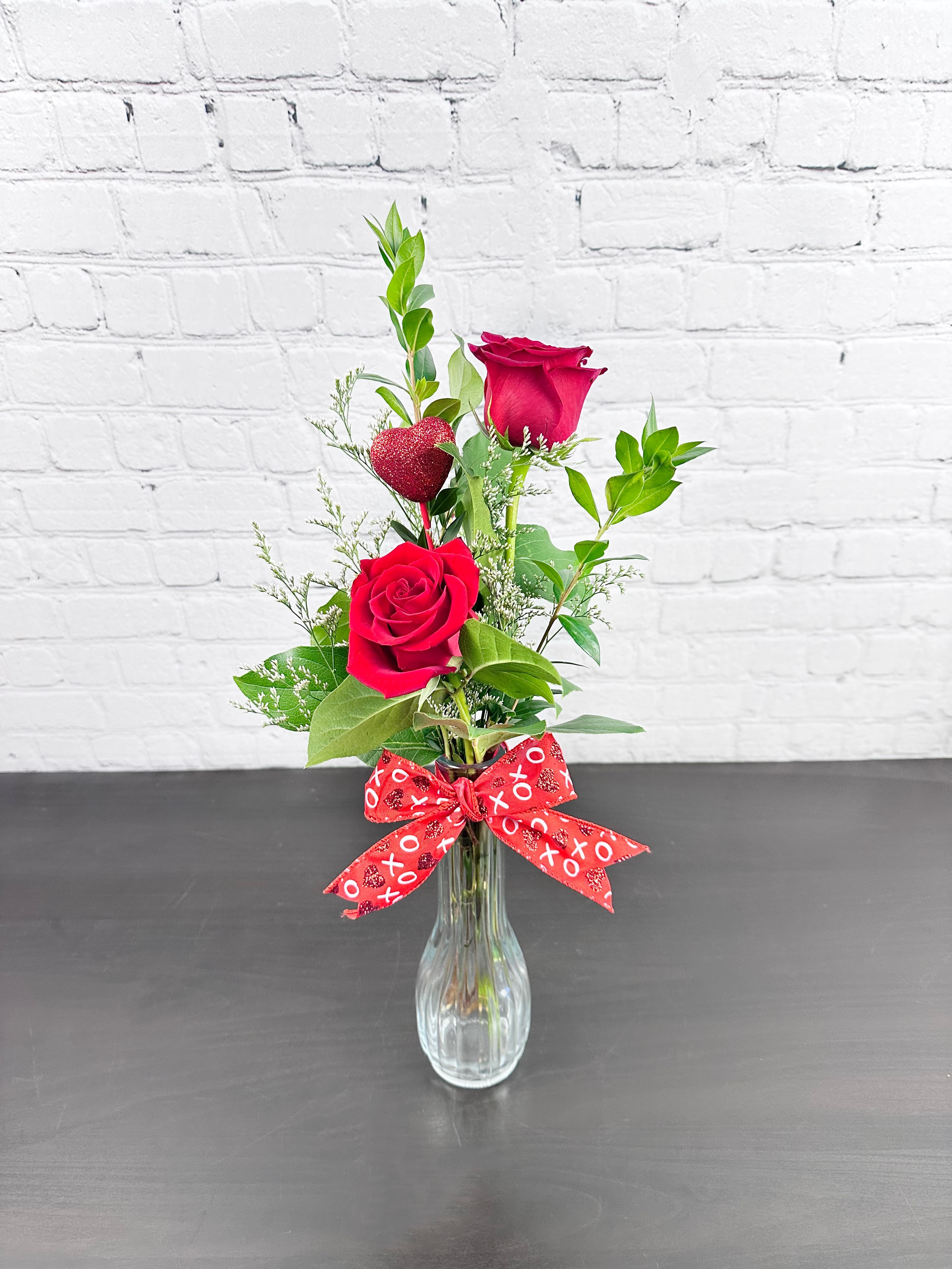 Just the Two of Us - Two red roses in a bud vase to represent the two of you! Stands approximately 14" tall and 5" wide.  Please Note: Standard Delivery for this product occurs in the afternoon, between 2:30pm and 7pm. If you need it by a certain time, there is an option to select a timed window for scheduled deliveries.