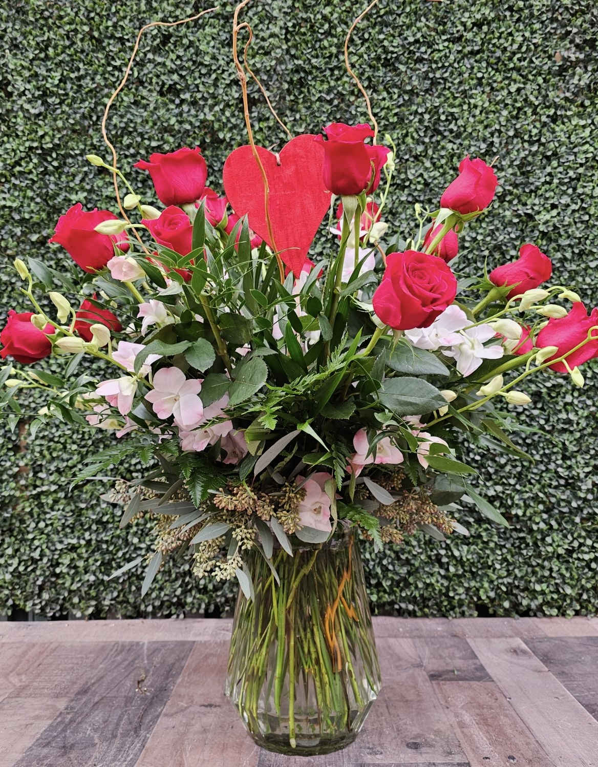 LOVESTRUCK - This romantic arrangement comes designed with 2 dozen red rose and pink dendrobium orchids. 